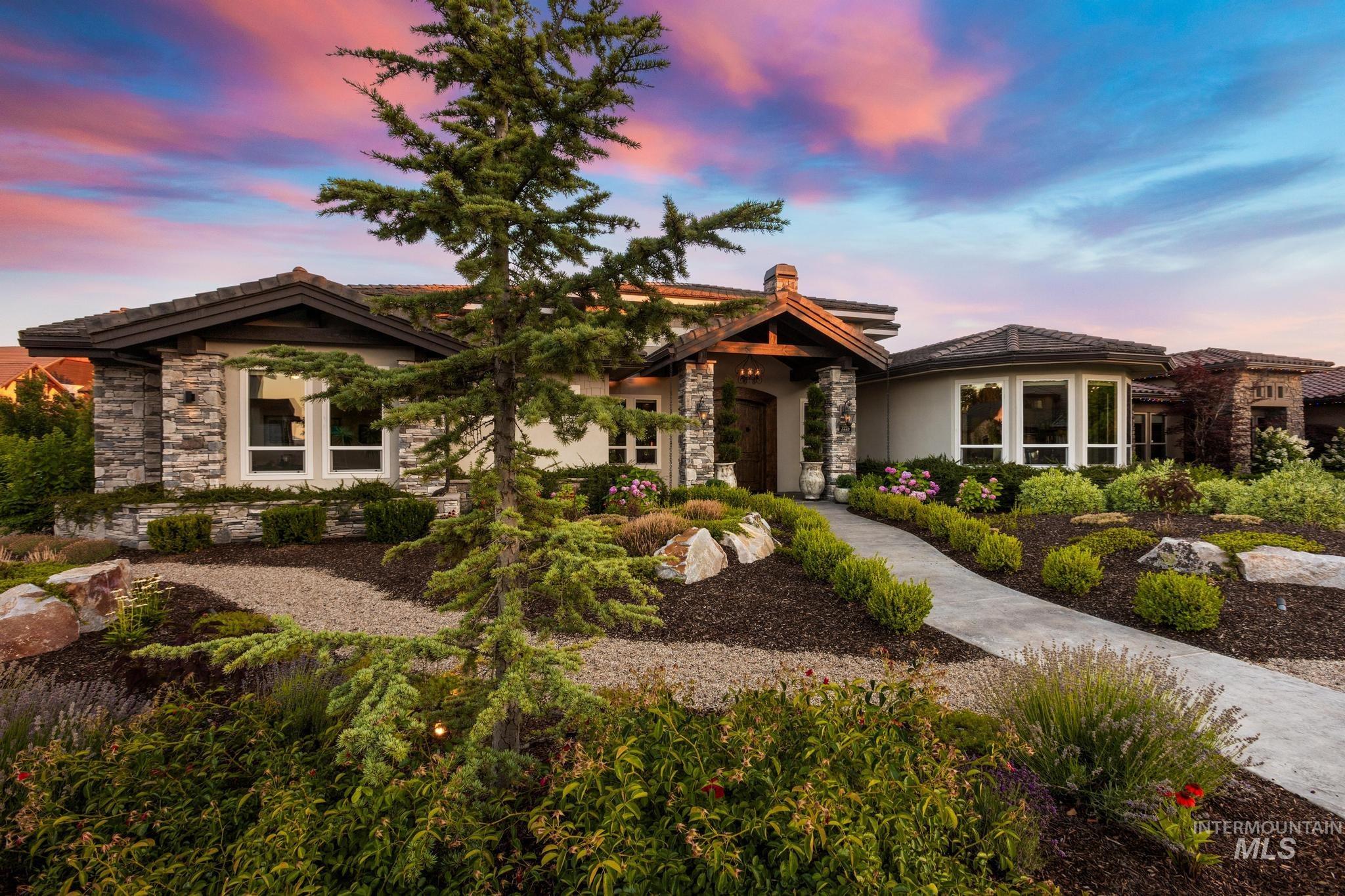 View of front facade featuring stone siding, a chimney, and a tile roof