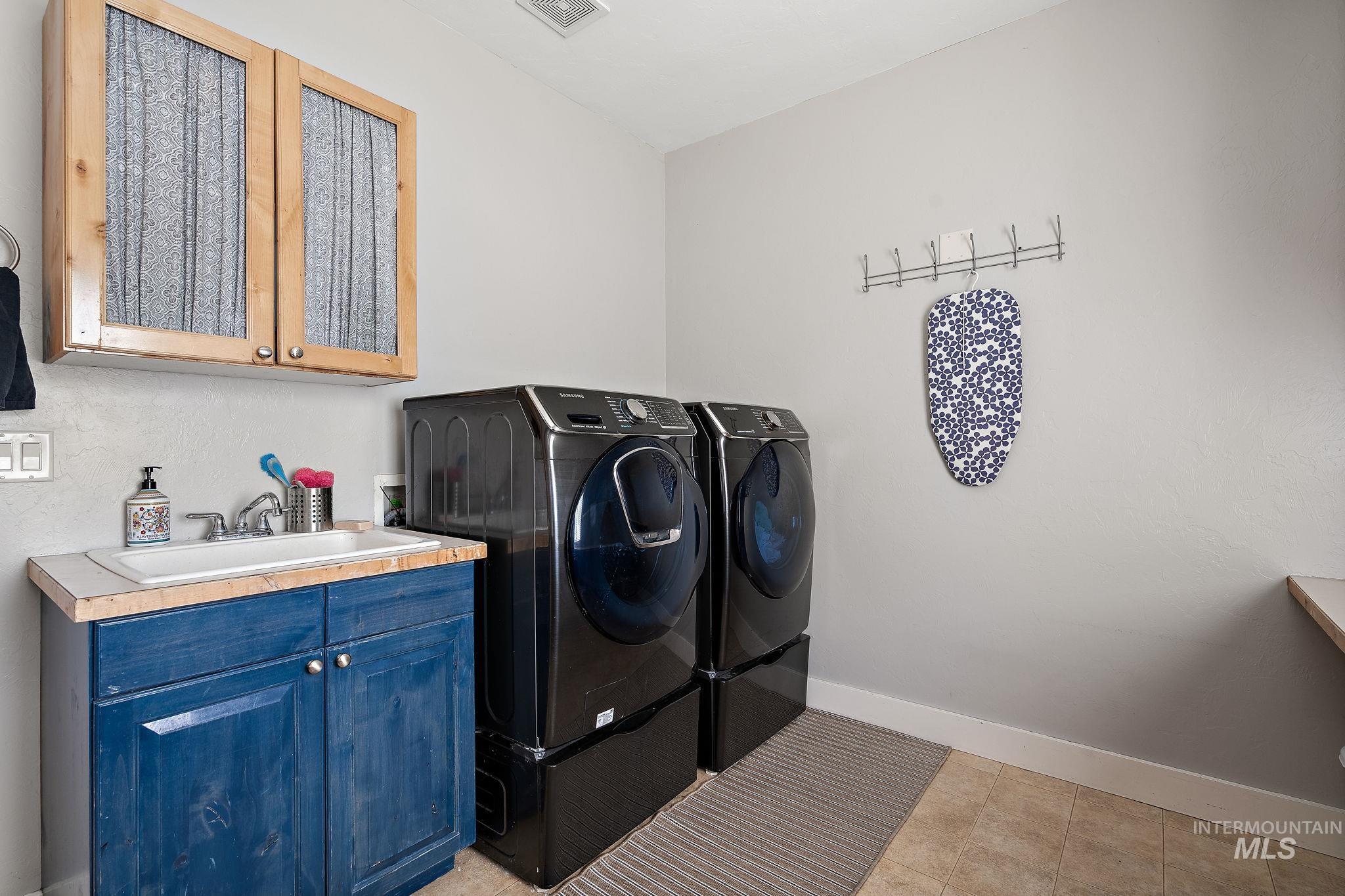 Laundry room featuring washer and clothes dryer and cabinet space