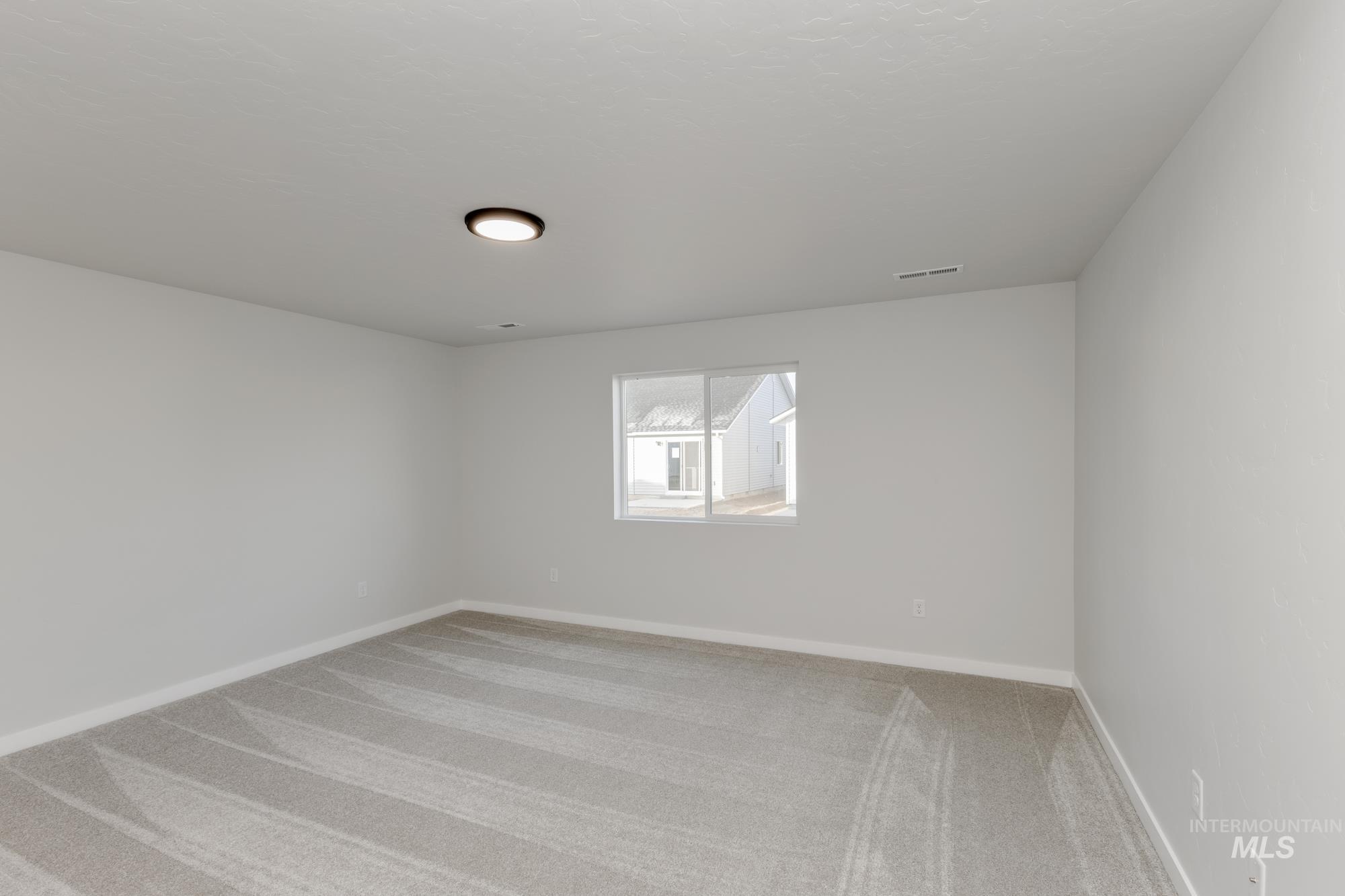 Empty room with light colored carpet