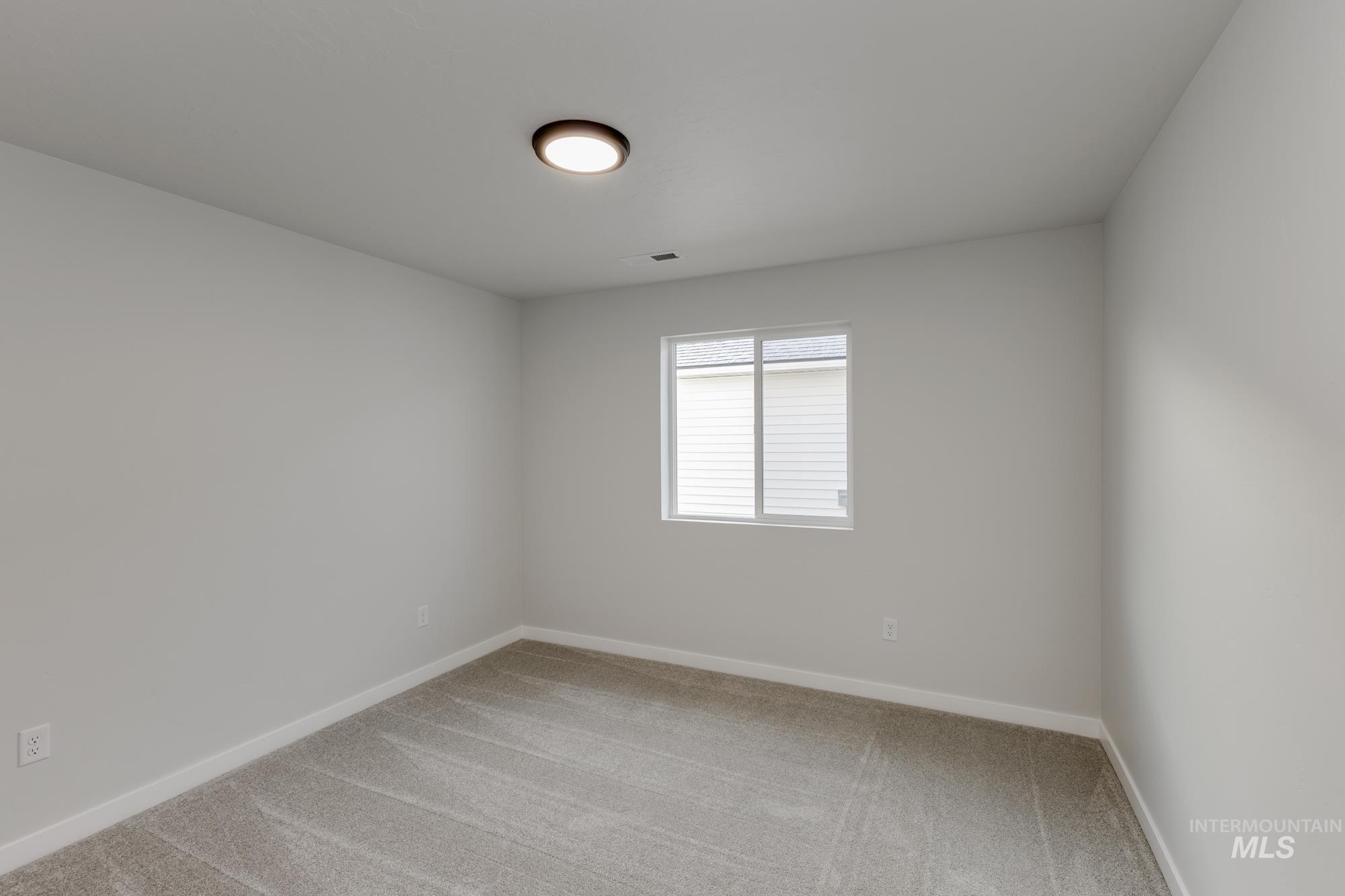 Unfurnished room with light colored carpet and baseboards