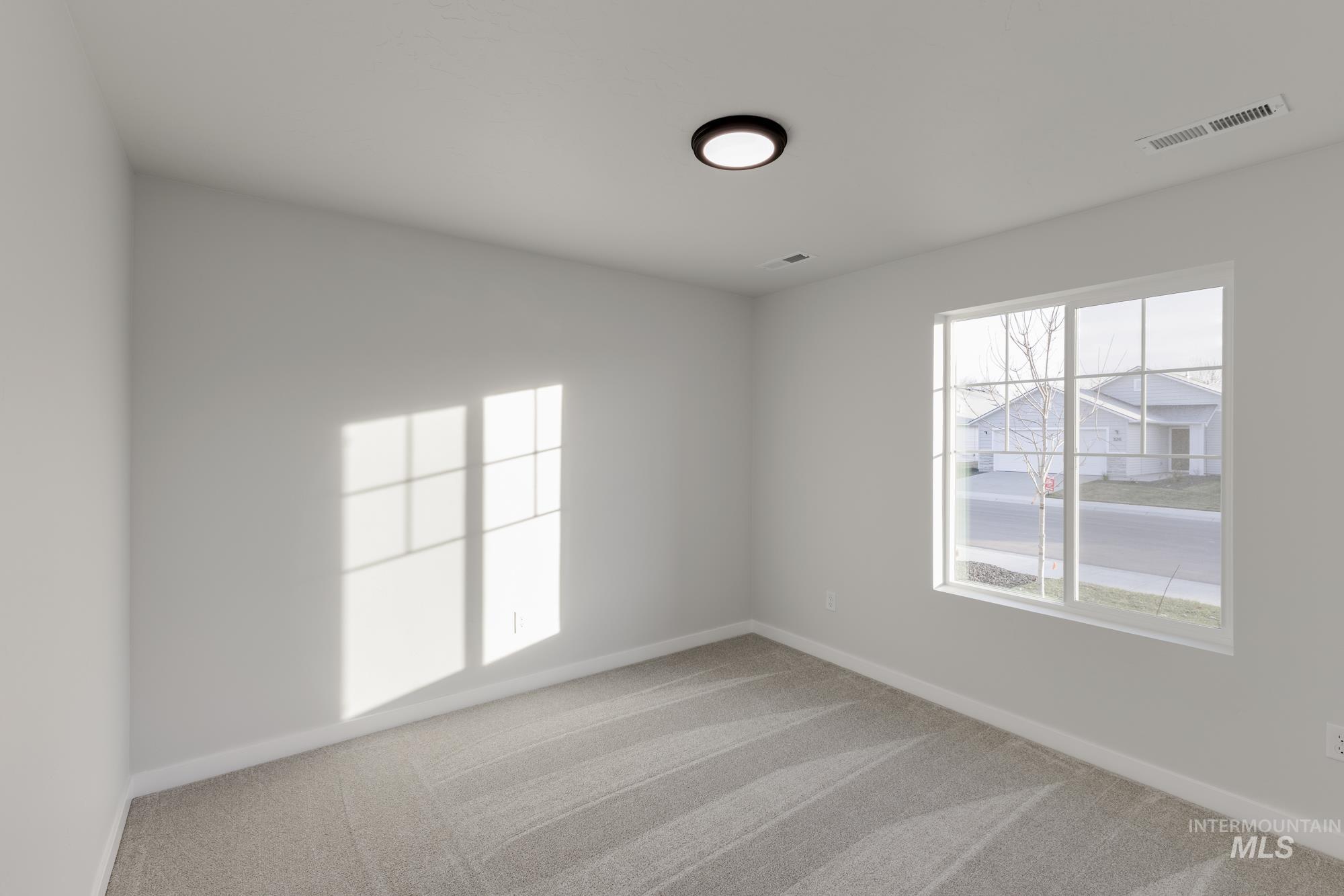 Spare room featuring light colored carpet and healthy amount of natural light