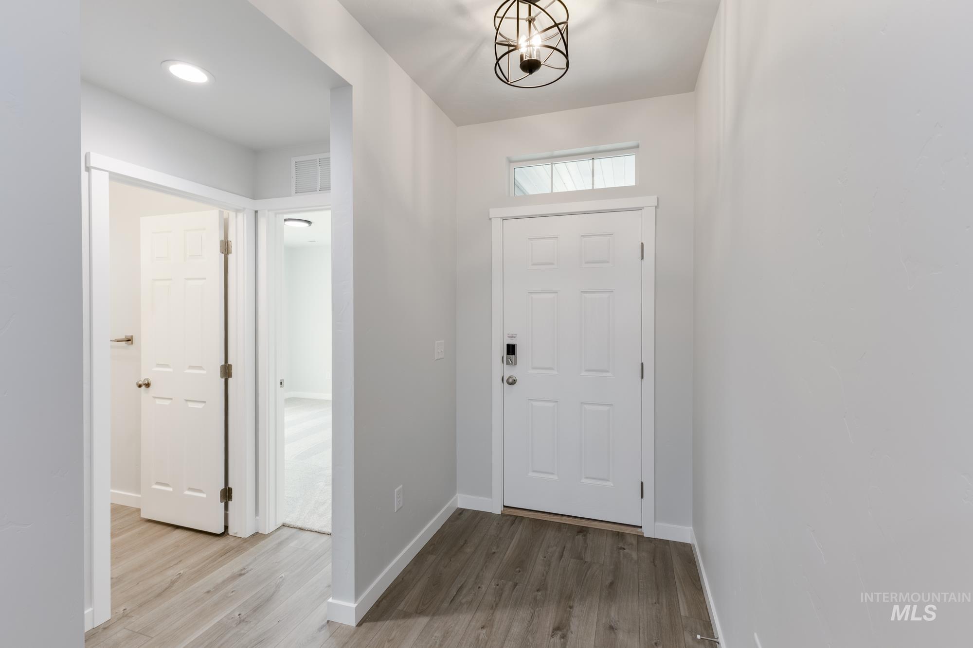 Foyer featuring light wood-type flooring and a chandelier