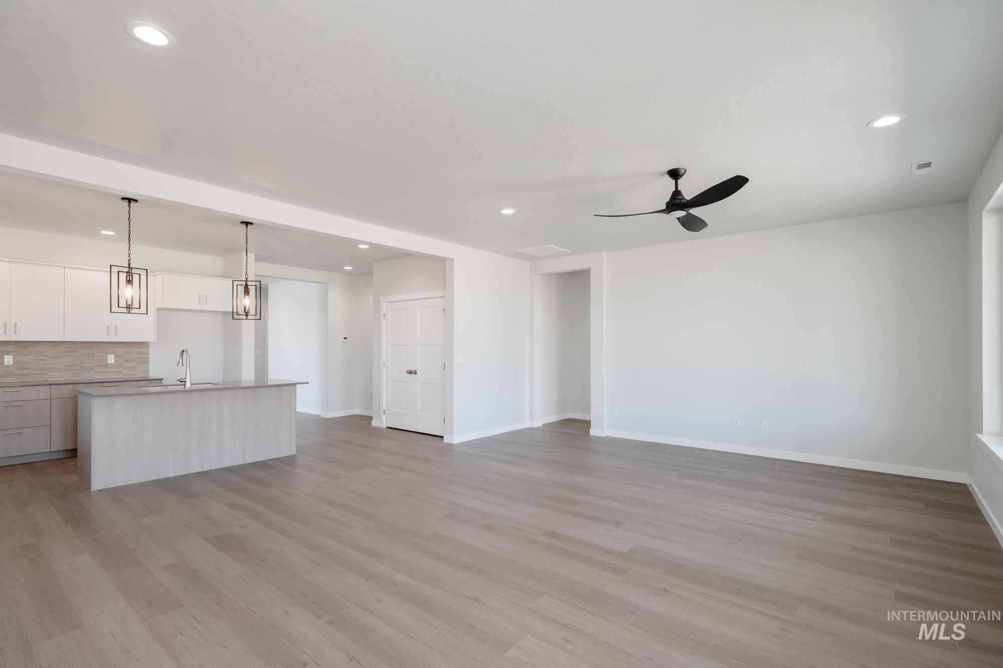 Unfurnished living room featuring recessed lighting, light wood-style flooring, and a ceiling fan
