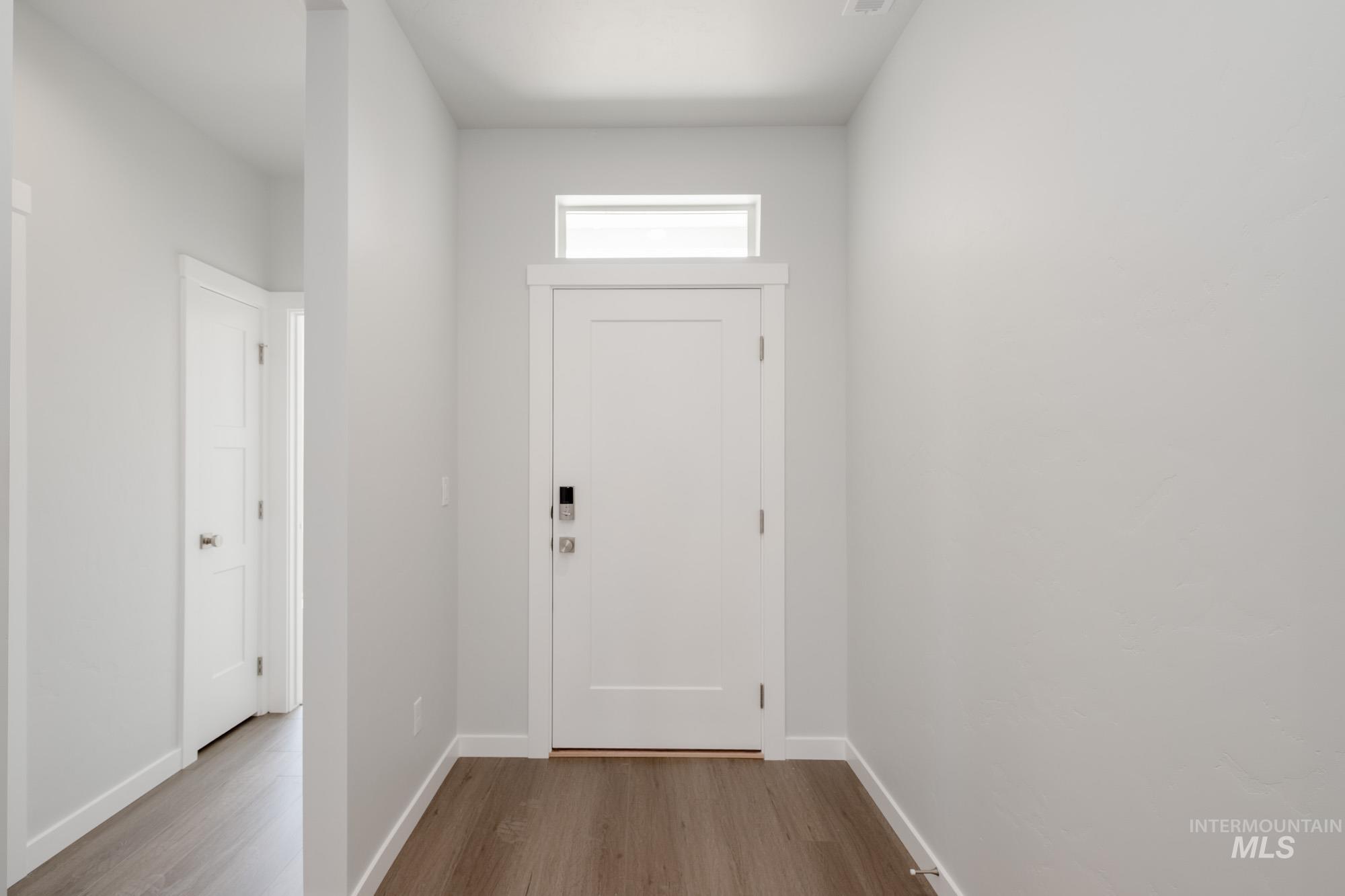Doorway to outside featuring wood finished floors and baseboards