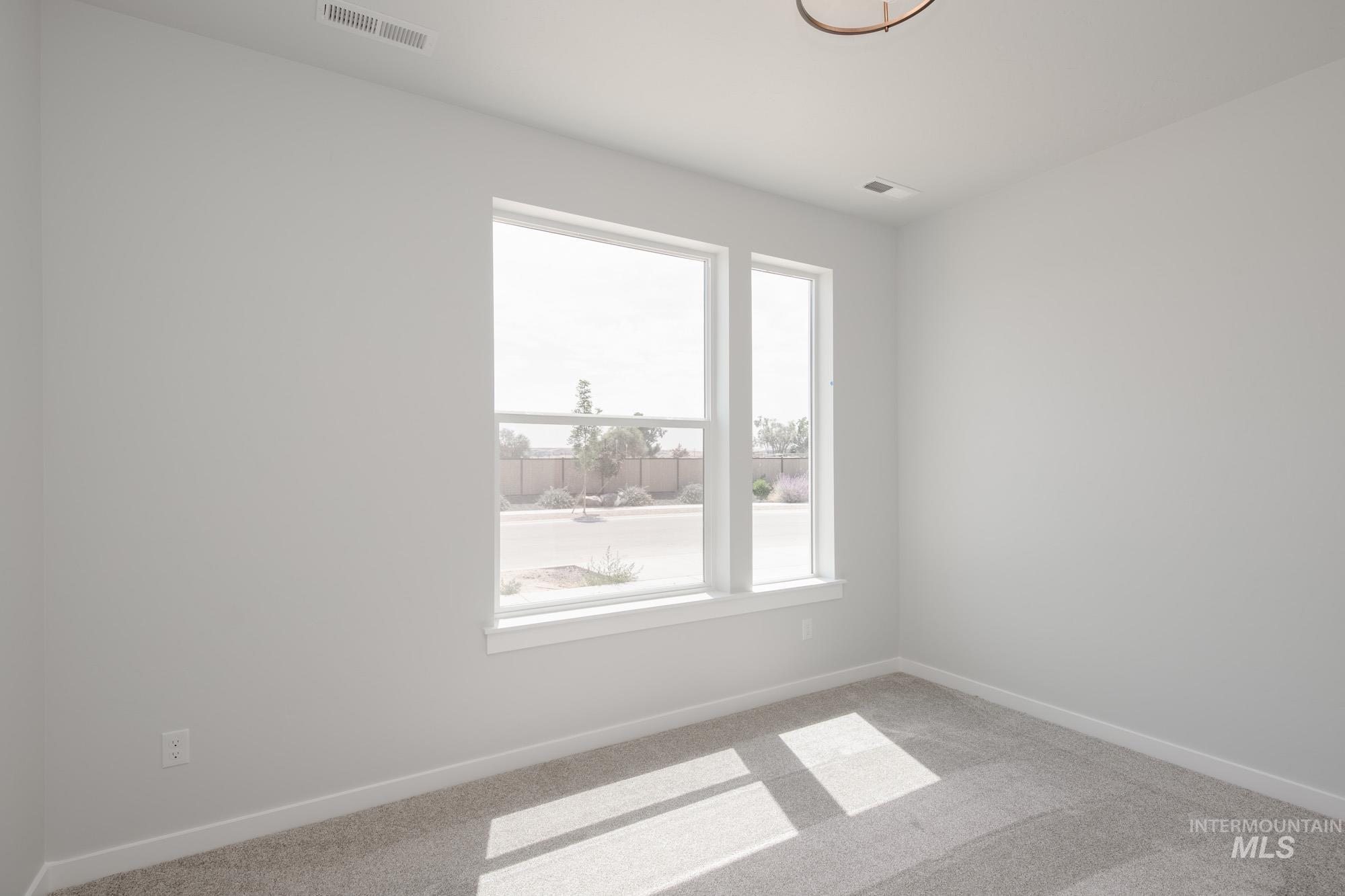 Spare room featuring carpet floors and baseboards