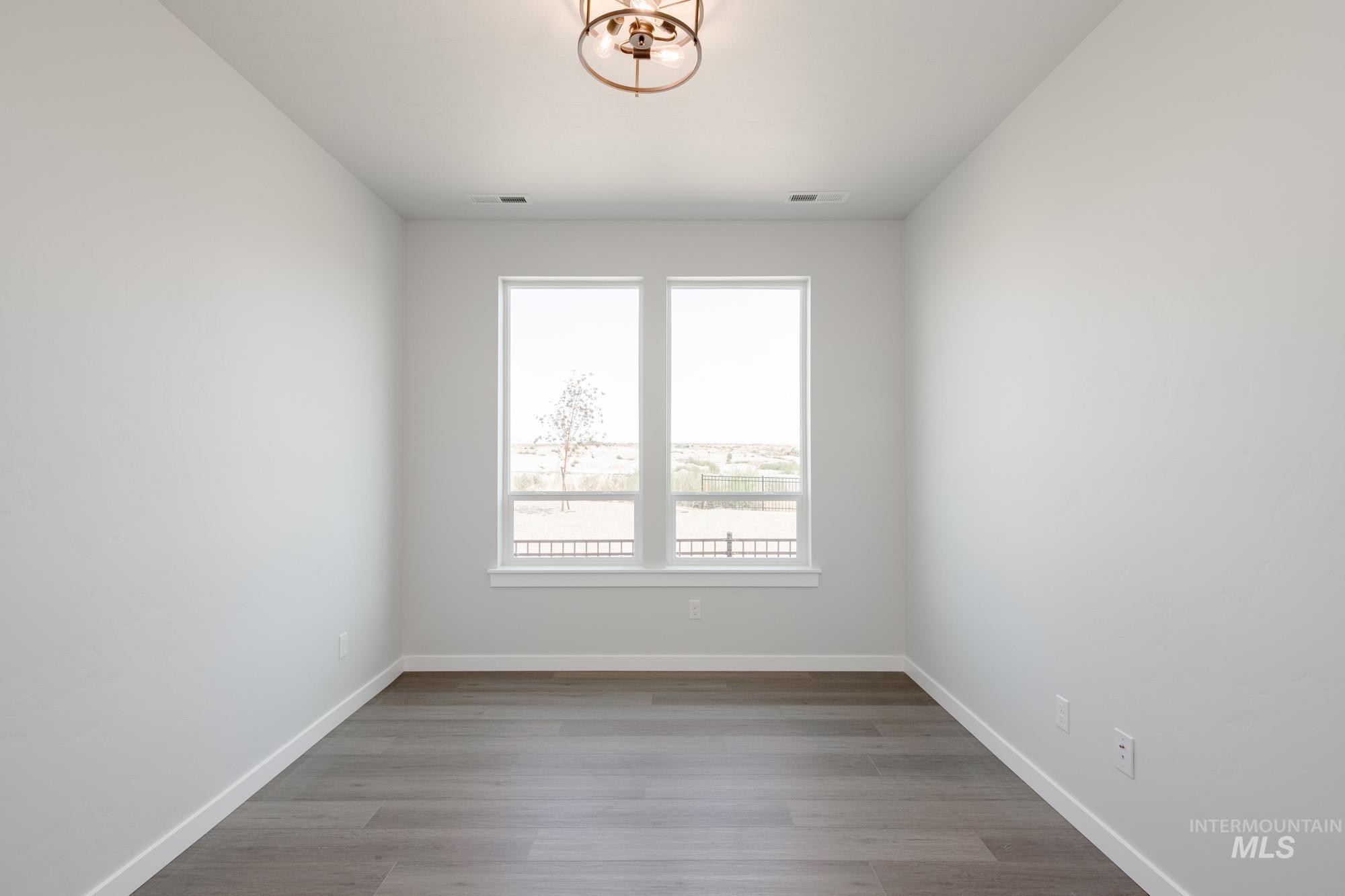 Spare room featuring baseboards and wood finished floors