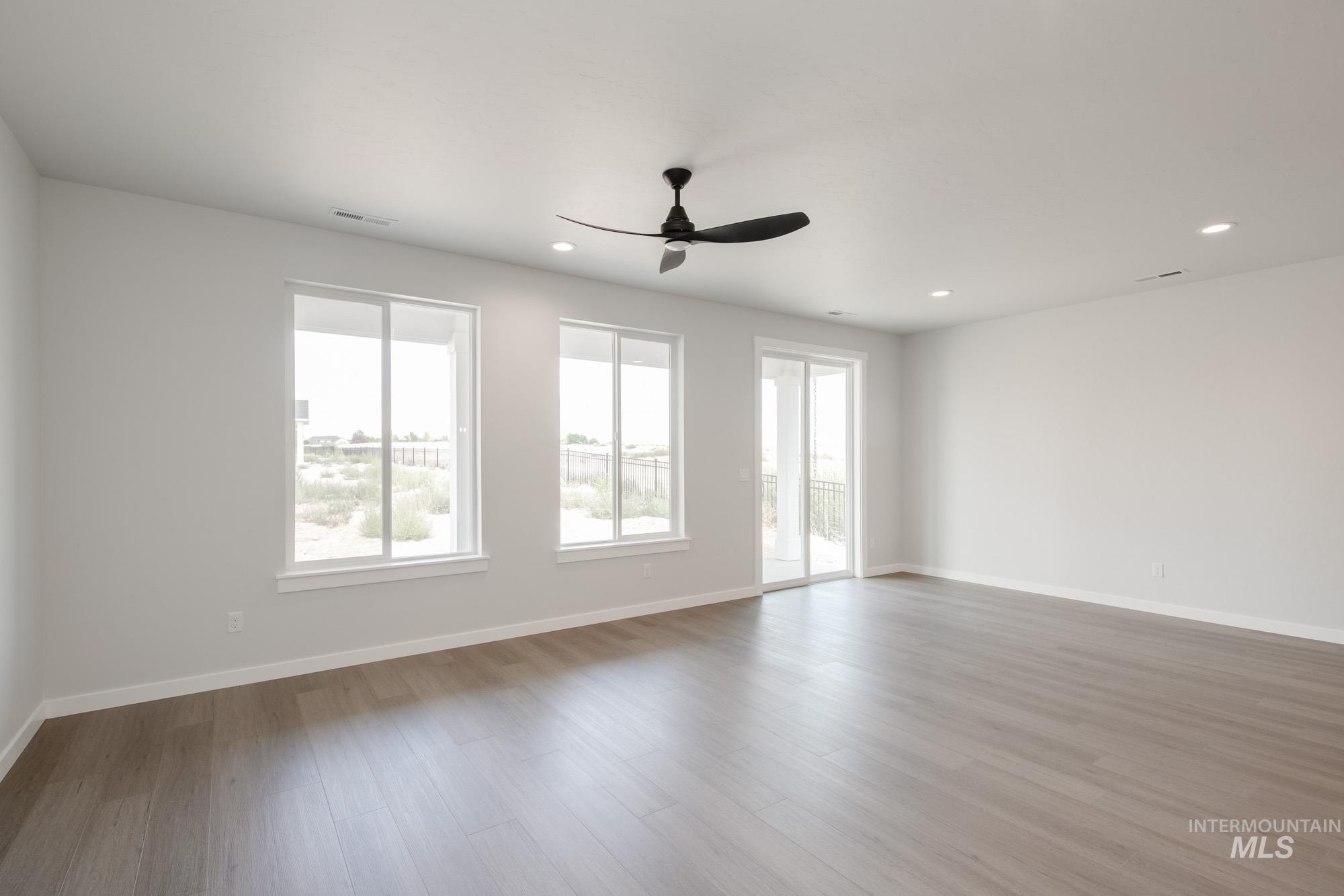 Empty room featuring wood finished floors, a ceiling fan, and recessed lighting