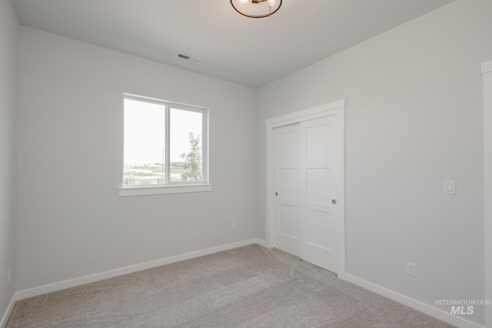 Unfurnished bedroom featuring light colored carpet and a closet