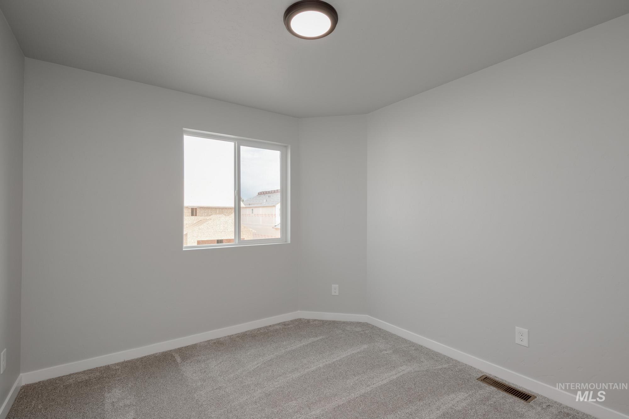 Empty room with carpet flooring and baseboards