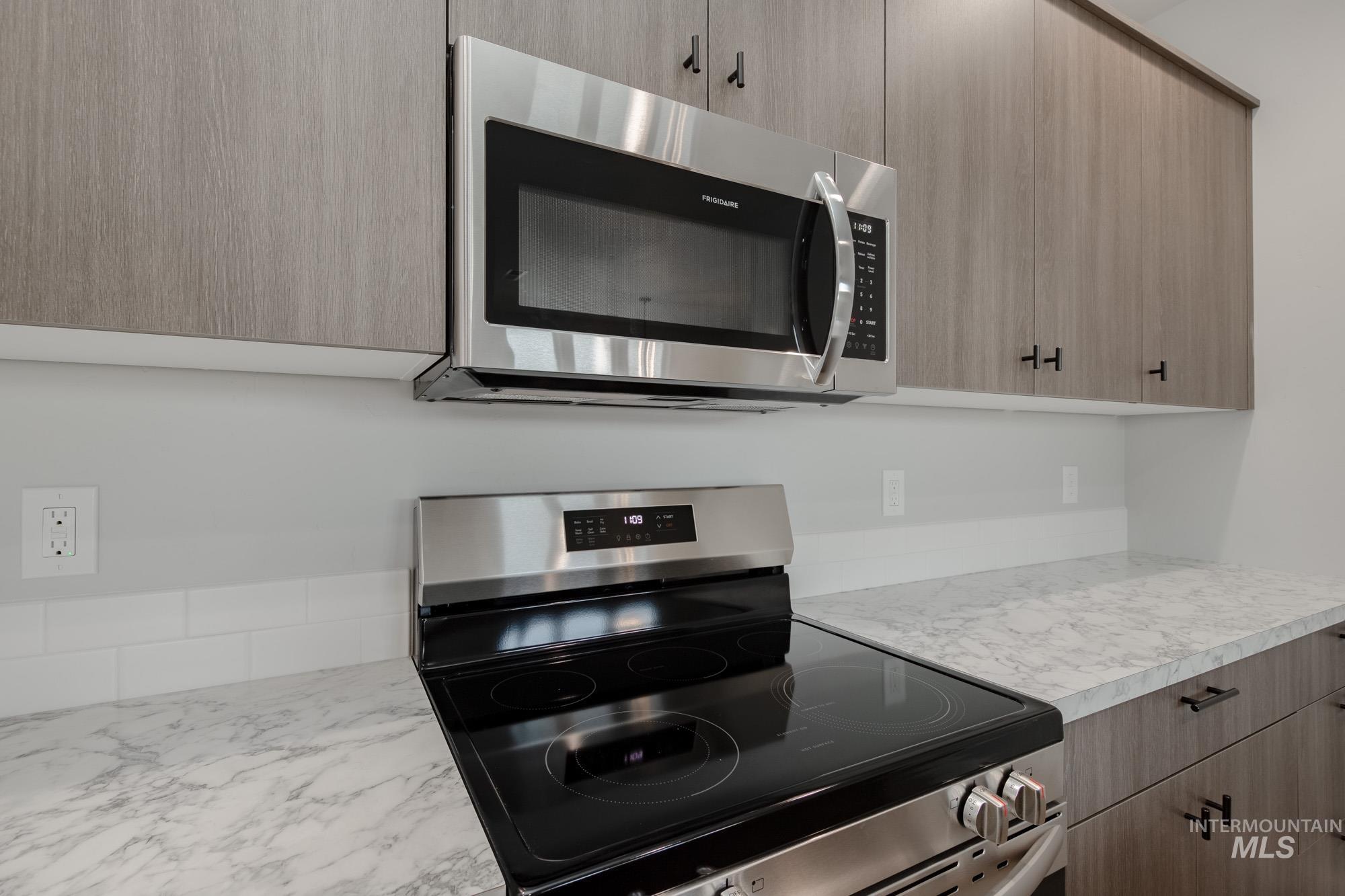 Kitchen featuring appliances with stainless steel finishes, light countertops, and modern cabinets
