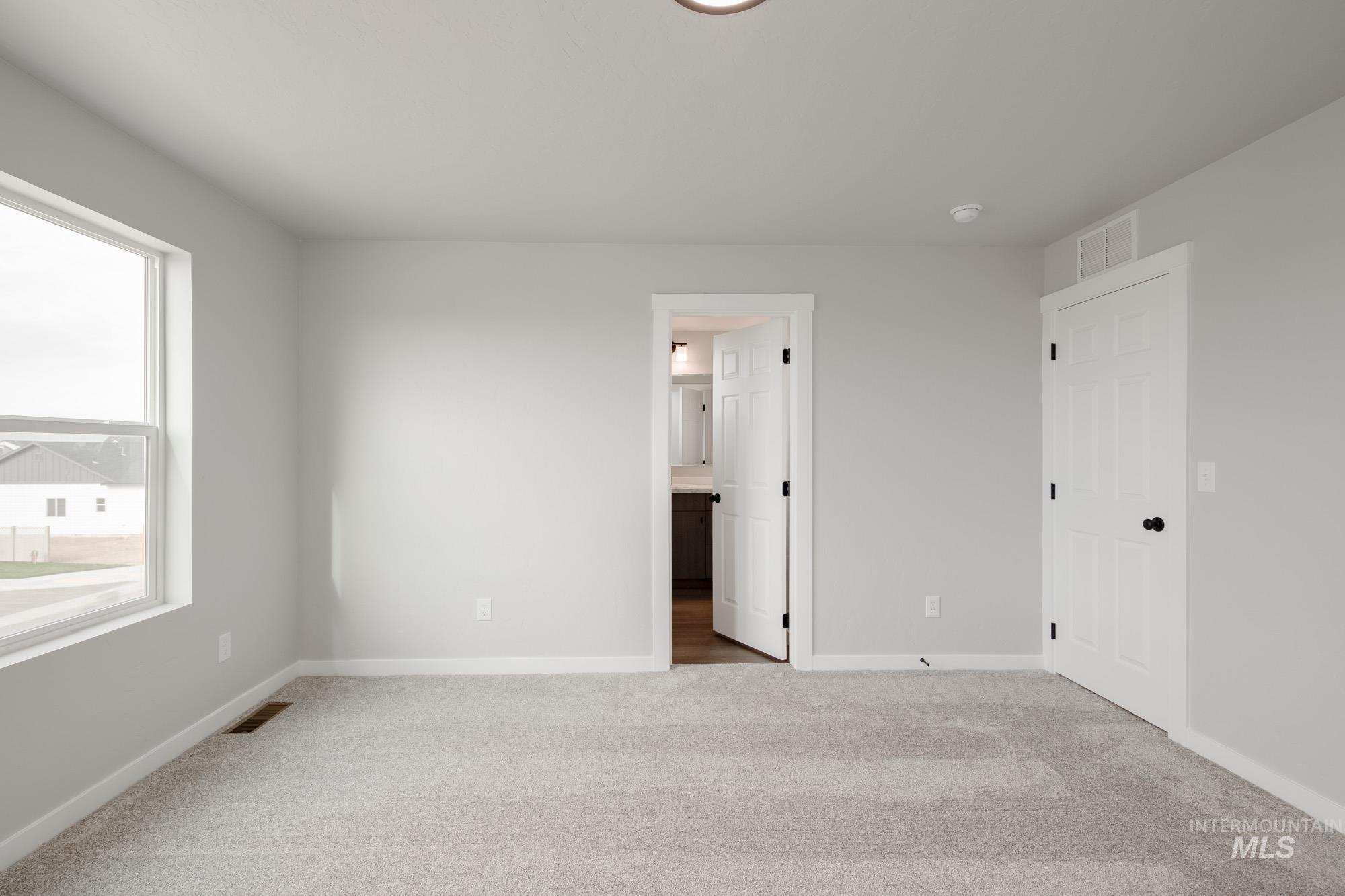 Unfurnished bedroom featuring carpet flooring and ensuite bath