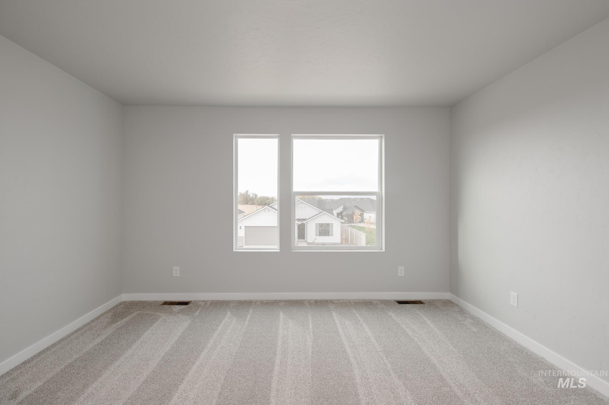 Empty room with carpet and baseboards