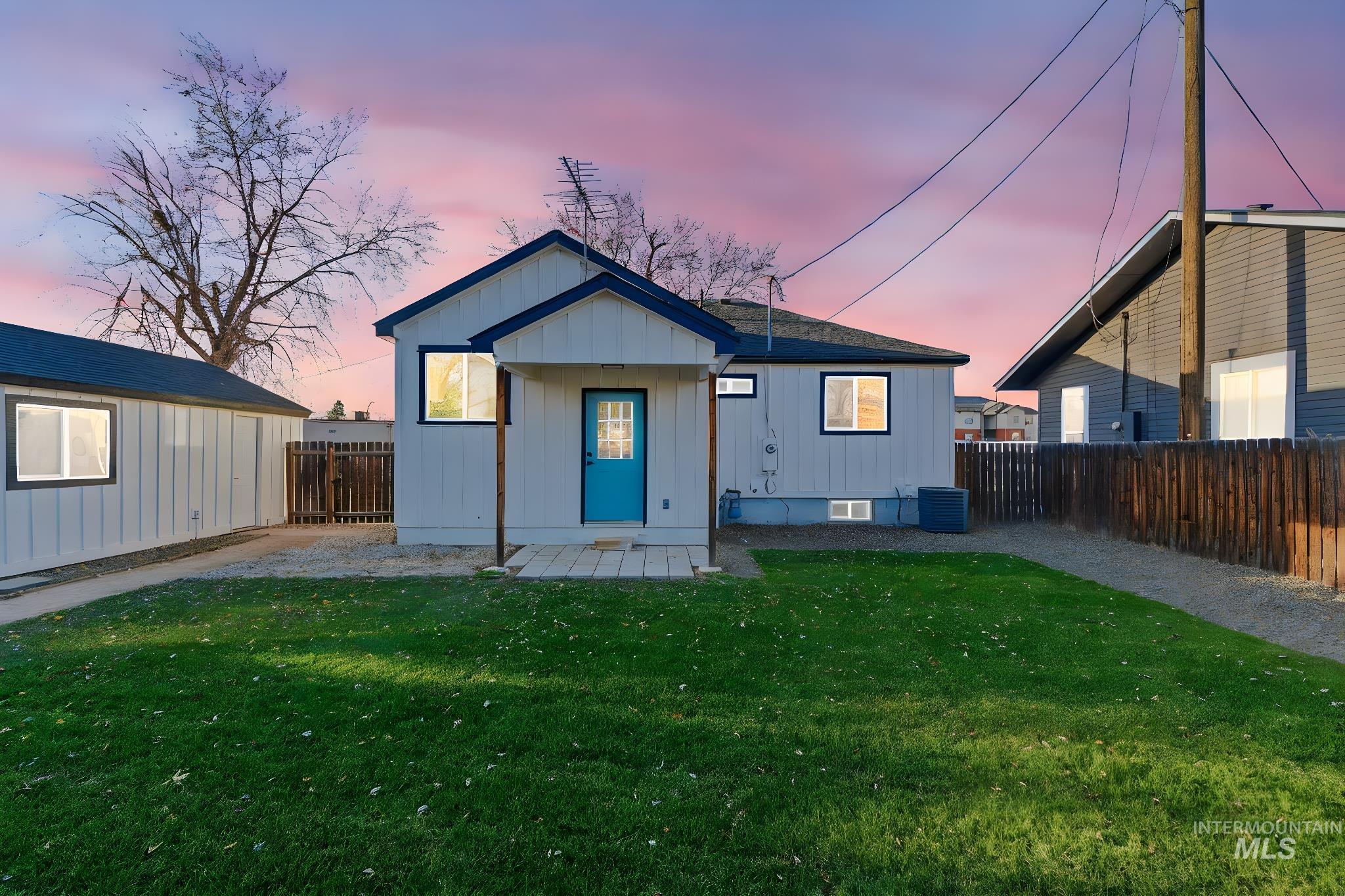 View of front of property with a fenced backyard, a patio area, and board and batten siding