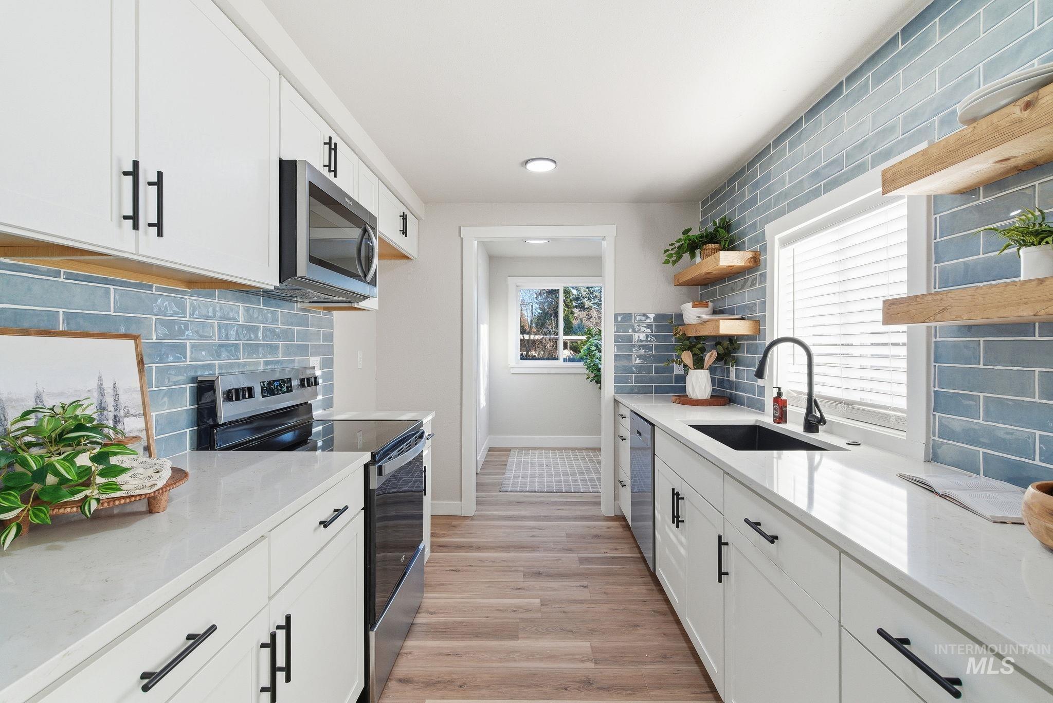 Kitchen featuring white cabinets, stainless steel appliances, and backsplash