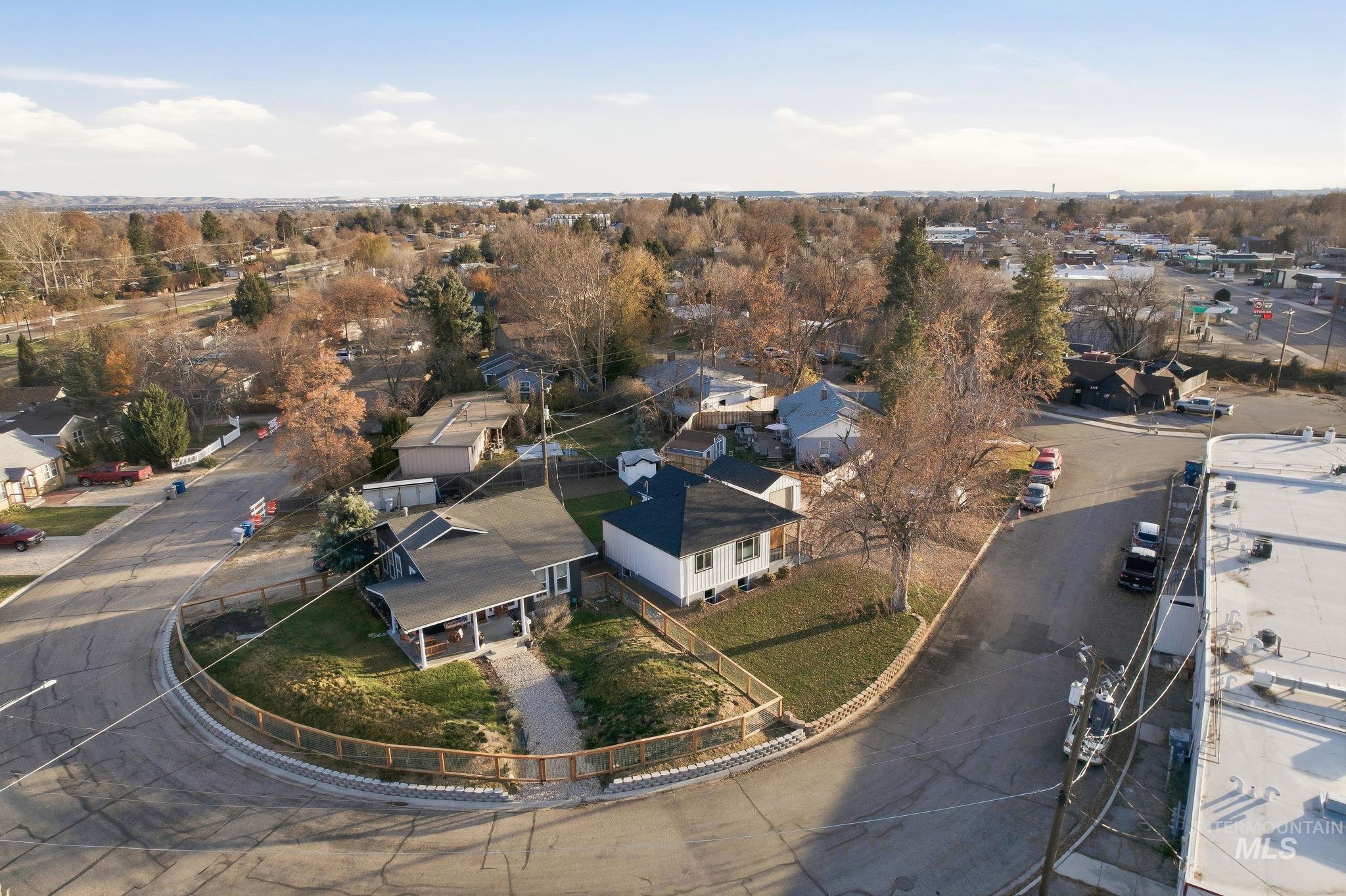 Aerial view of property and surrounding area featuring nearby suburban area