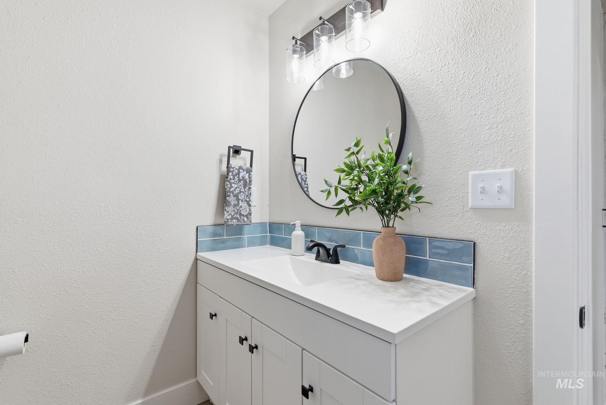 Bathroom featuring a textured wall and vanity