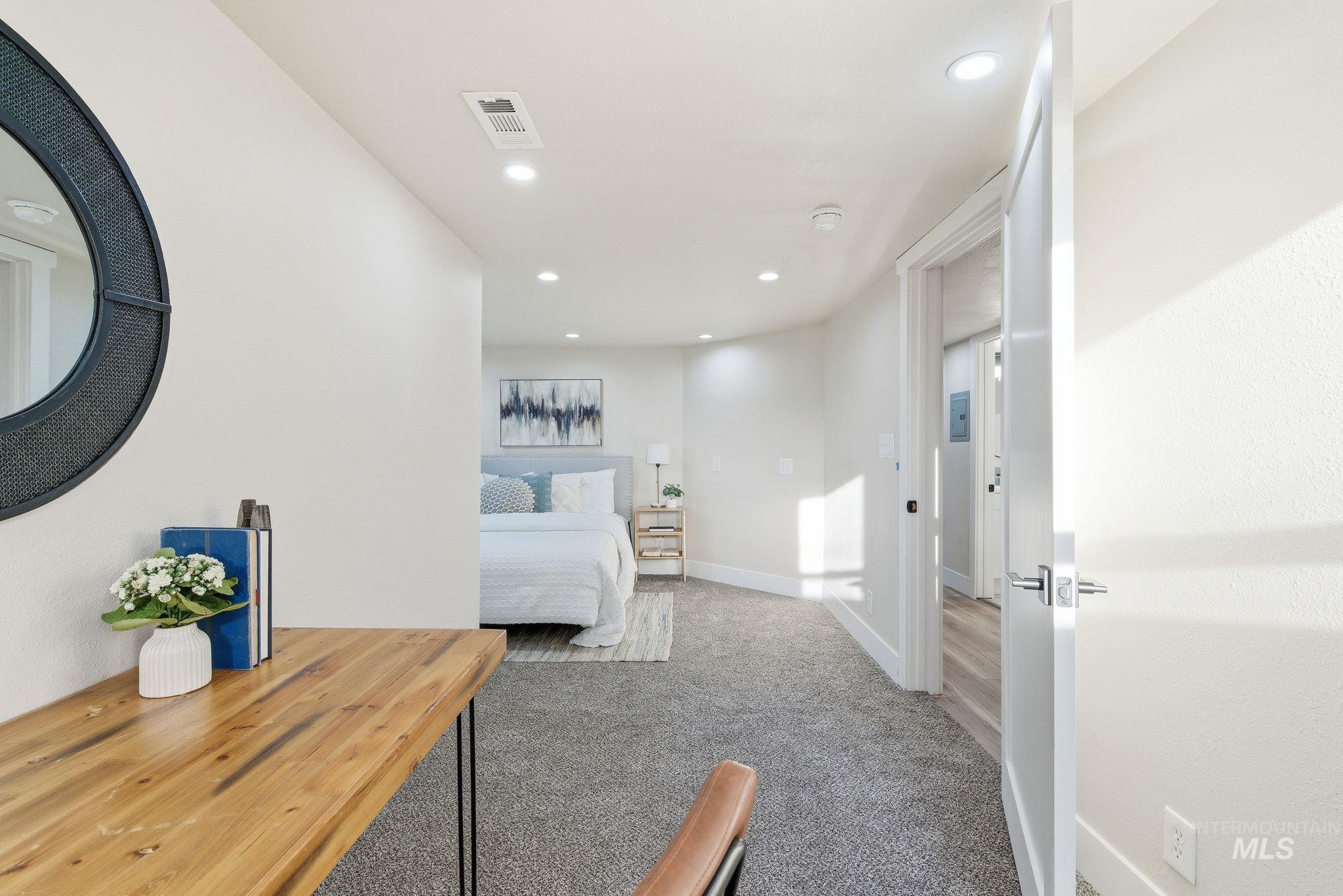Bedroom with light colored carpet and recessed lighting