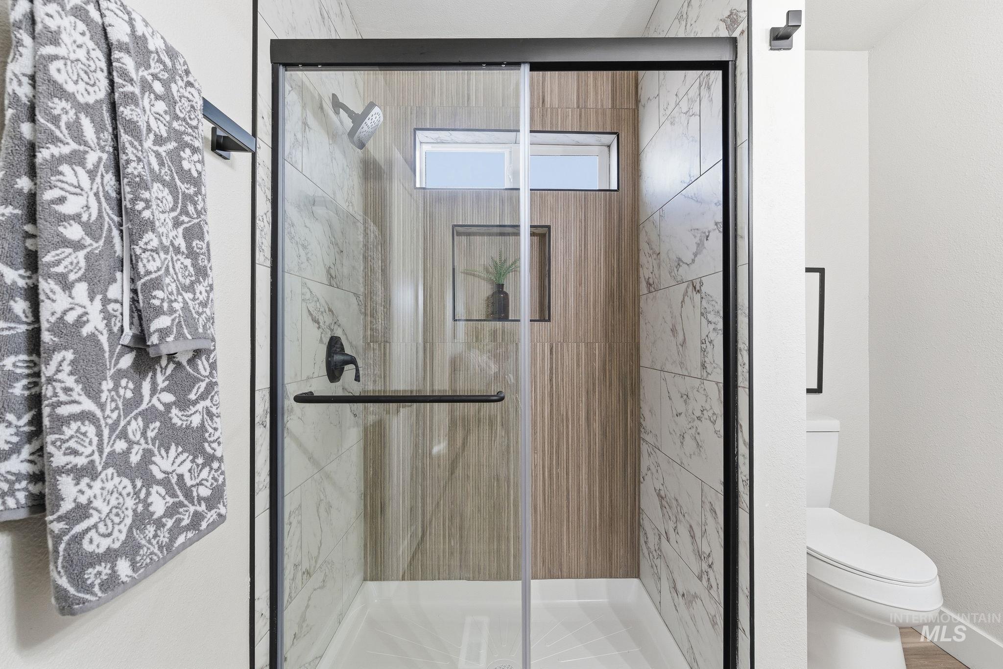 Full bathroom with a shower stall and toilet