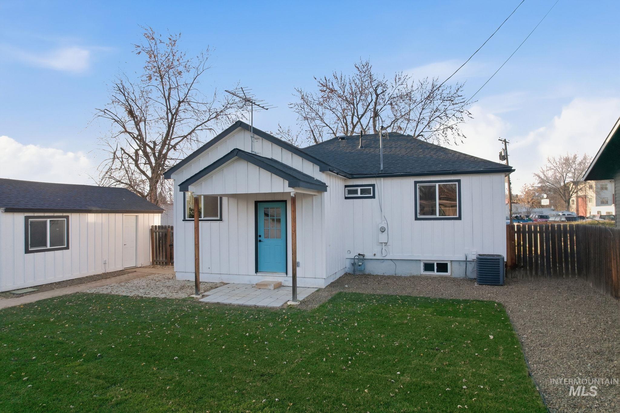 Rear view of property with a fenced backyard, a shingled roof, and board and batten siding