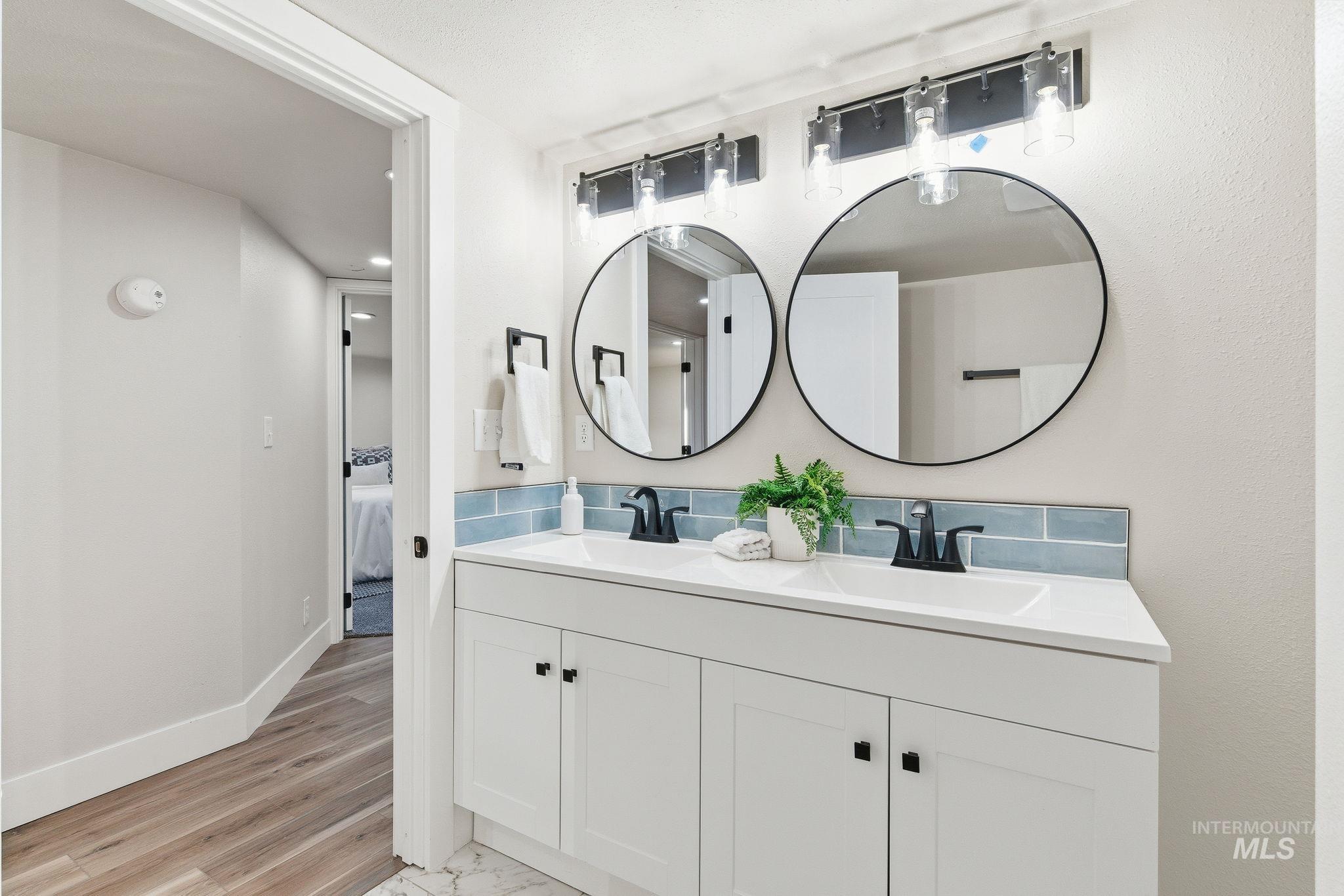 Ensuite bathroom with double vanity and baseboards
