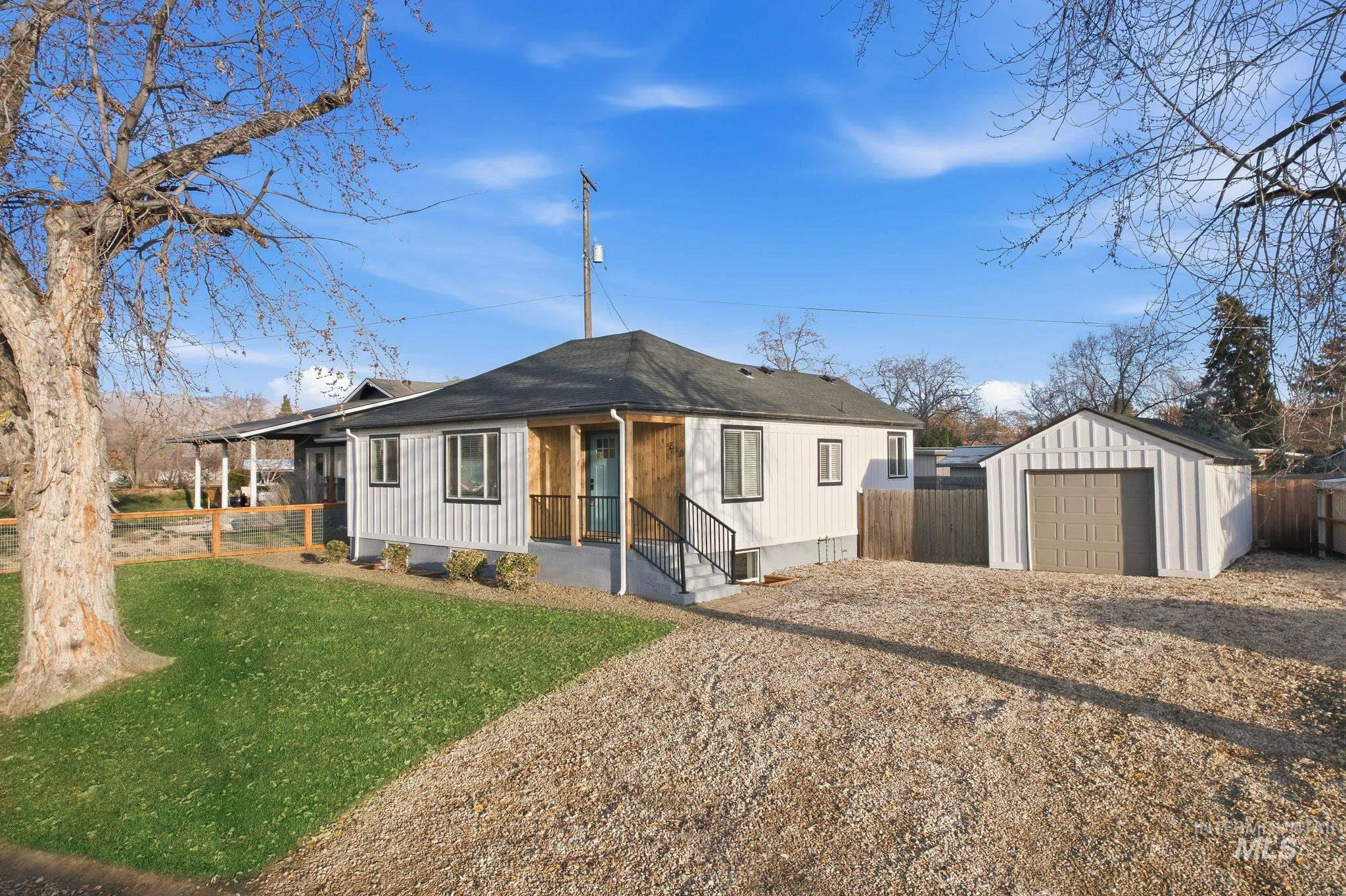 View of front facade with an outbuilding and a shingled roof