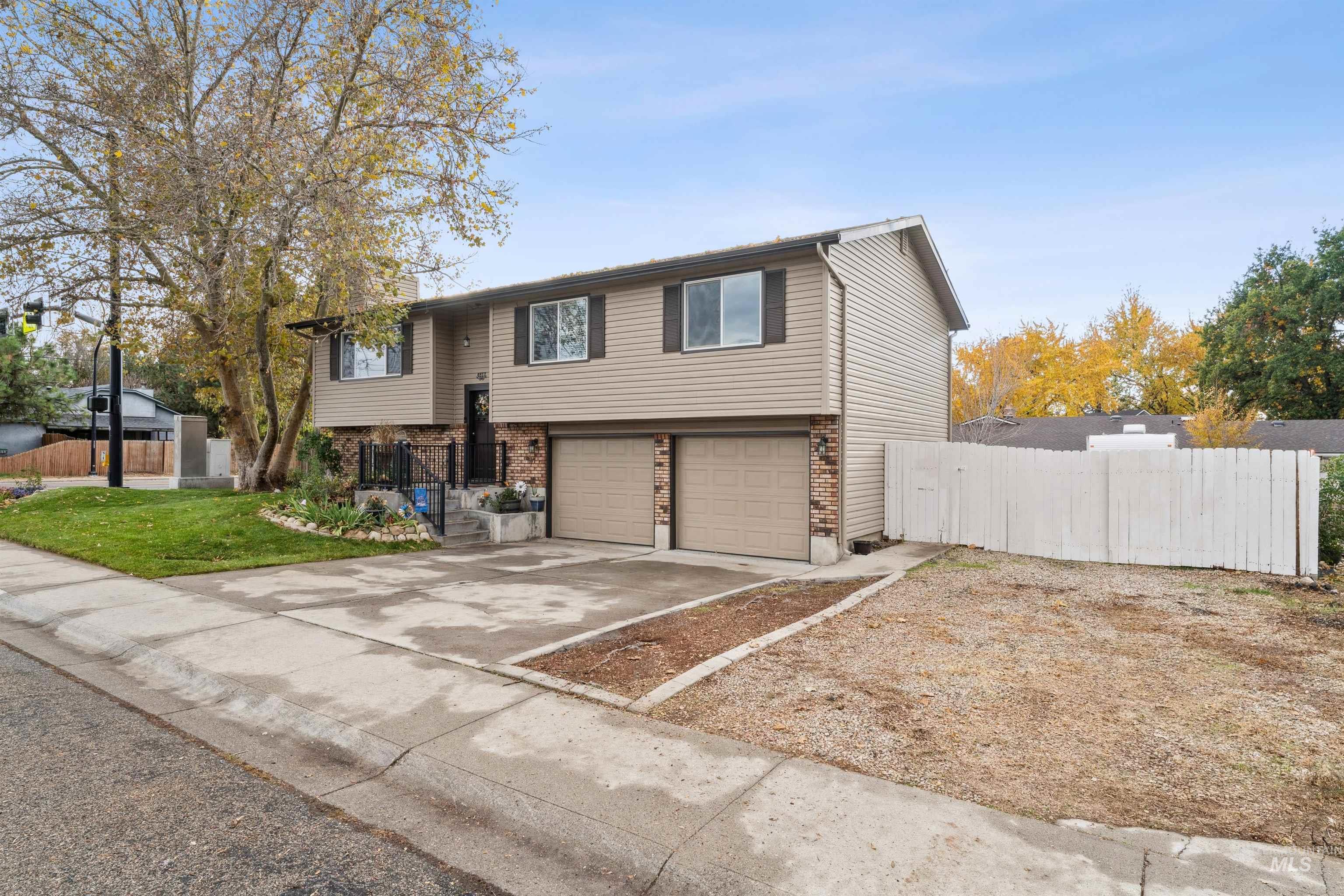 Bi-level home featuring brick siding, driveway, and an attached garage