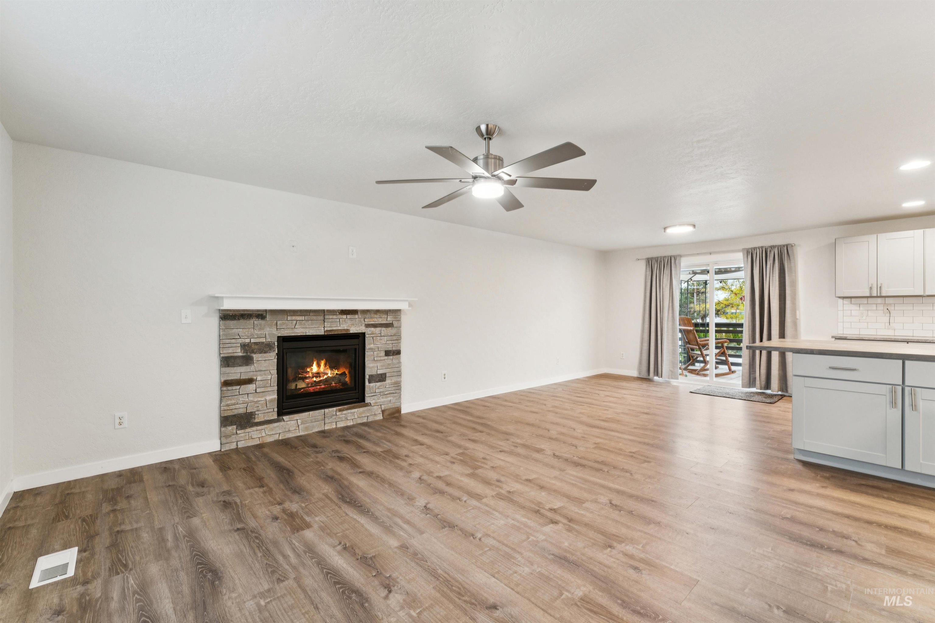 Unfurnished living room featuring a fireplace, light wood-type flooring, a ceiling fan, and recessed lighting