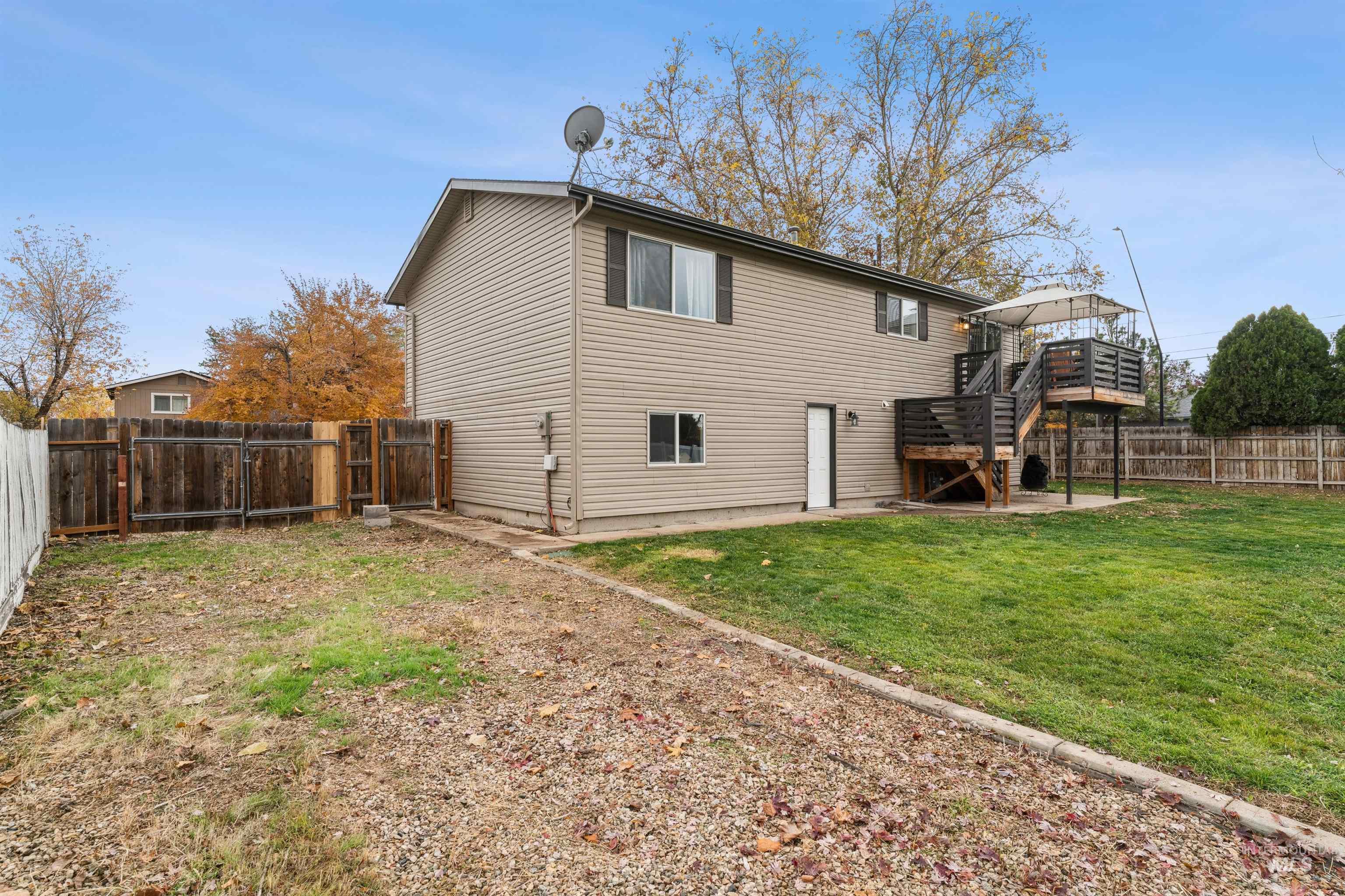 Rear view of property featuring a fenced backyard, stairs, a deck, and a patio