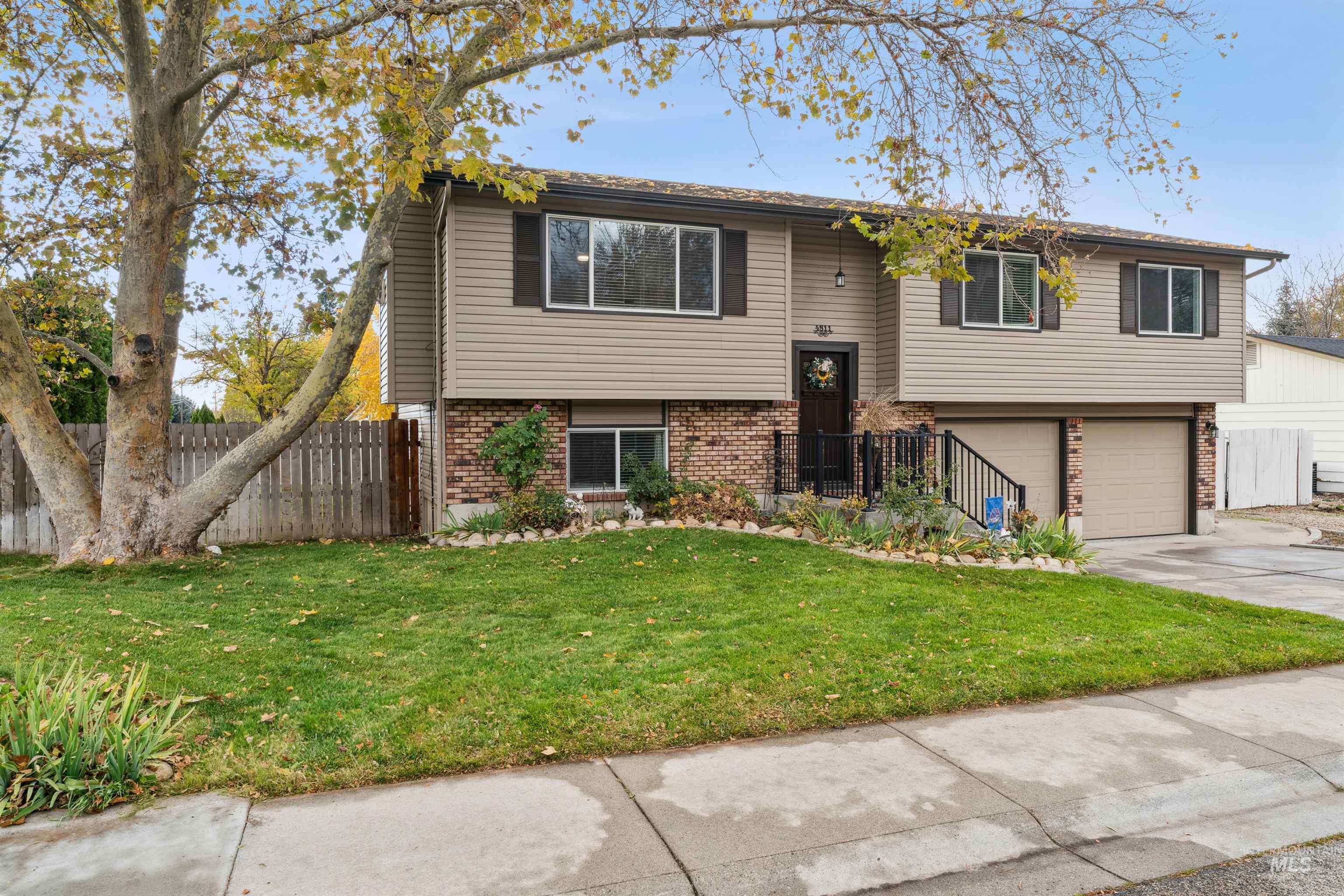 Bi-level home featuring brick siding, driveway, and a garage
