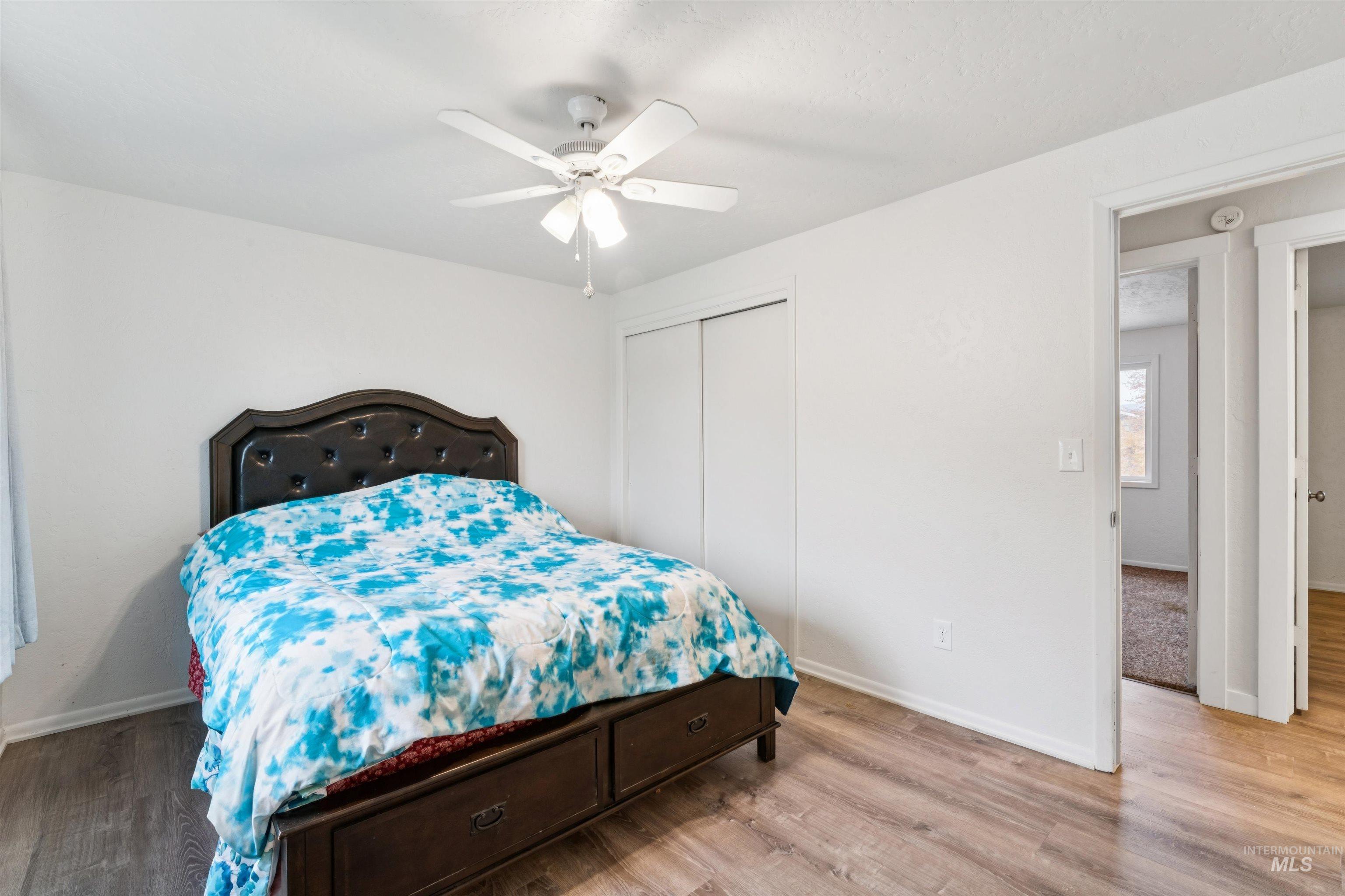 Bedroom featuring wood finished floors, a ceiling fan, and a closet