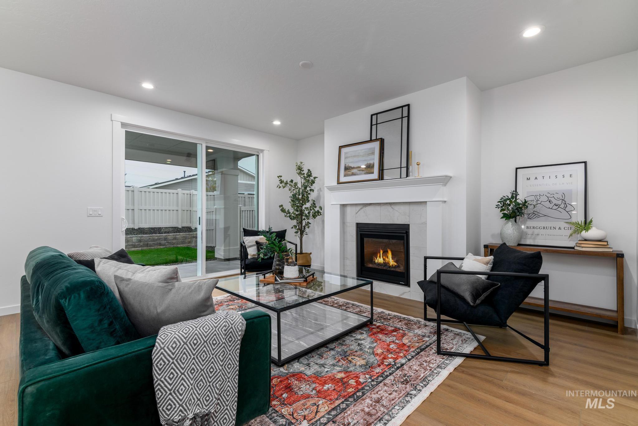 Living area with light wood-type flooring, a tiled fireplace, and recessed lighting