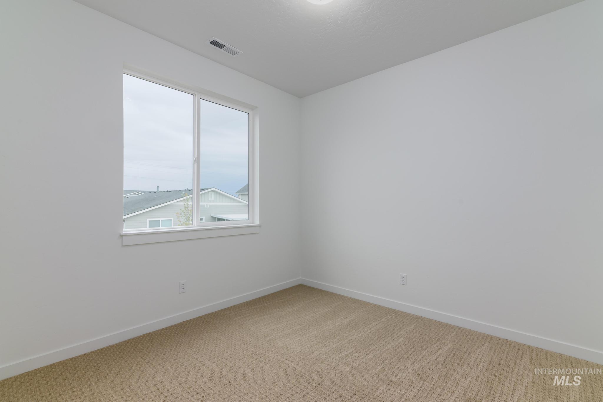Empty room with light carpet and baseboards