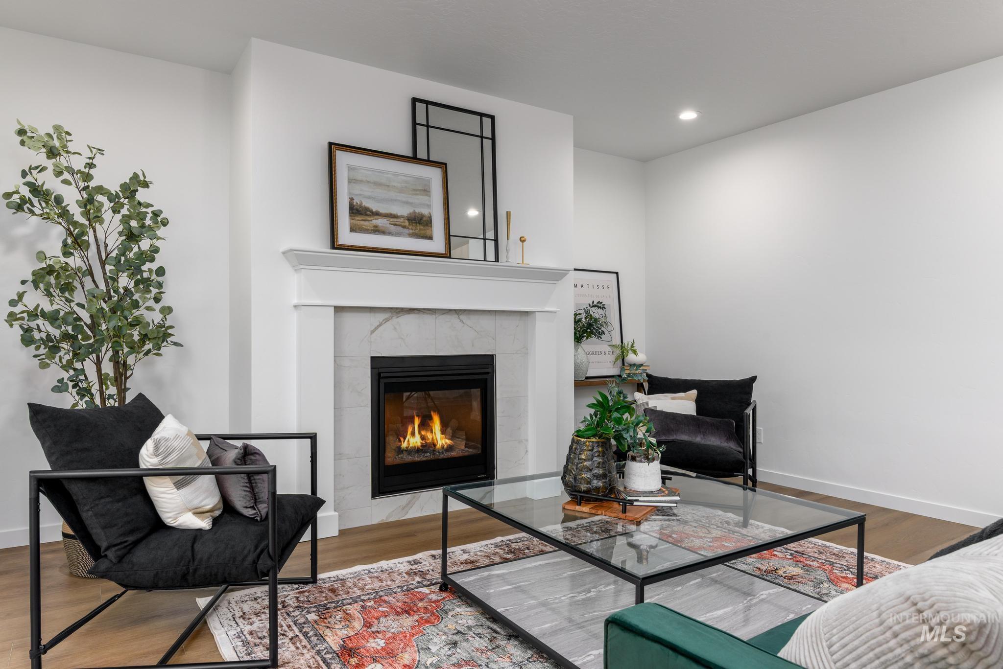 Sitting room featuring wood finished floors, a tiled fireplace, and recessed lighting