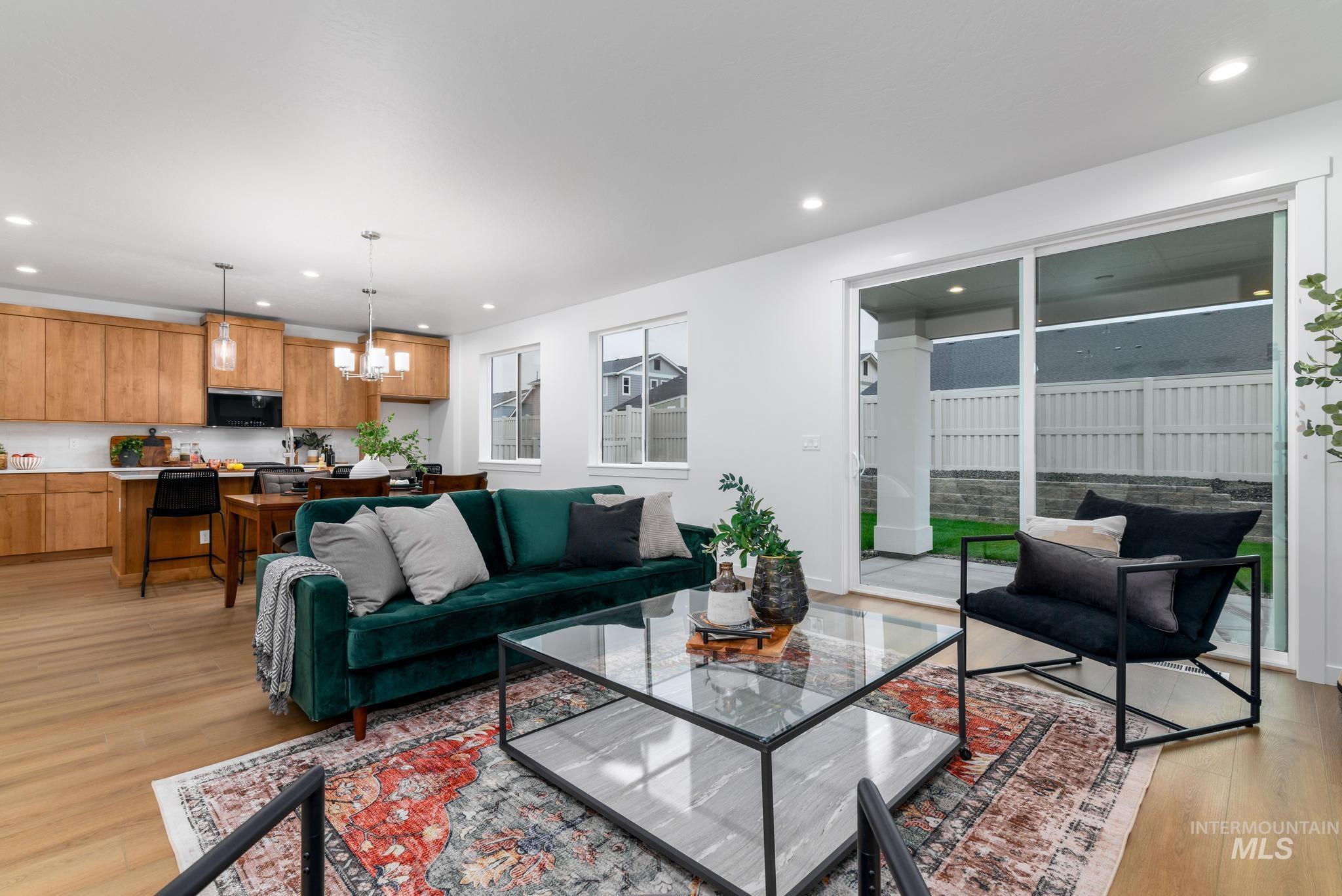 Living room with light wood finished floors, recessed lighting, and a chandelier