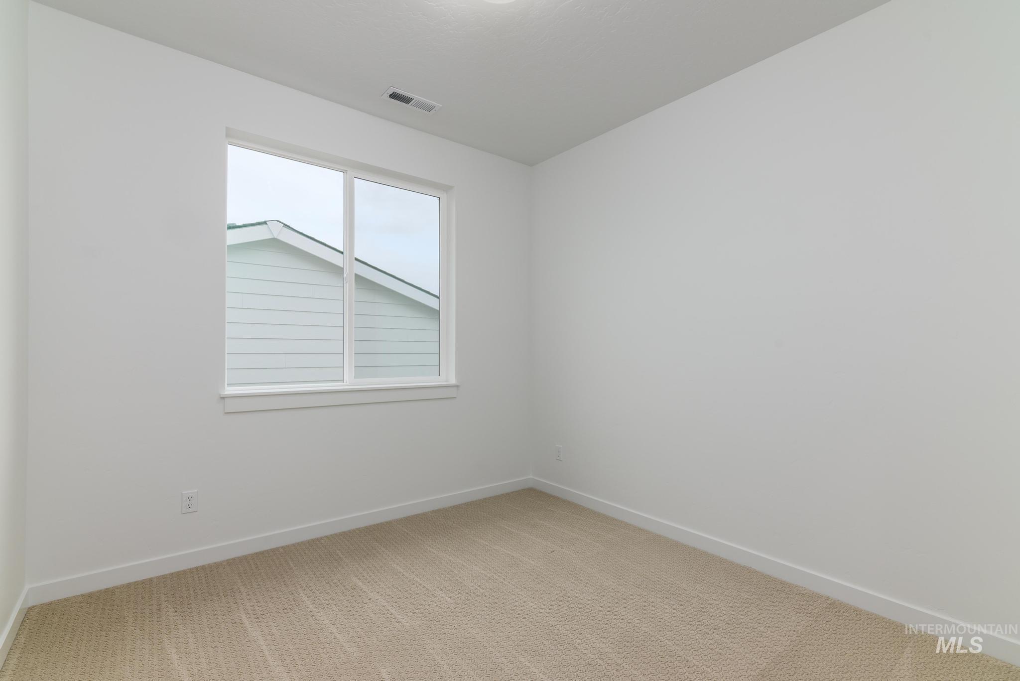 Spare room with carpet and baseboards