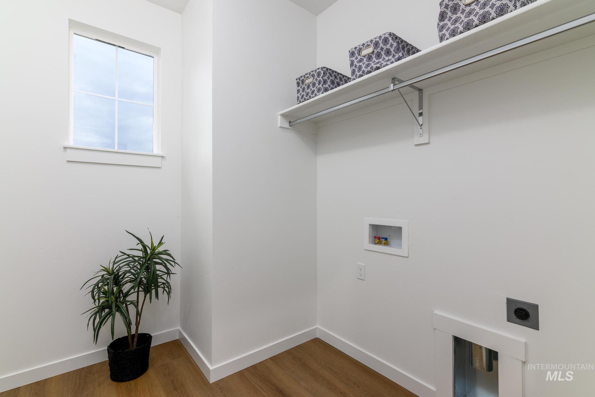 Laundry room featuring wood finished floors, hookup for a washing machine, and electric dryer hookup