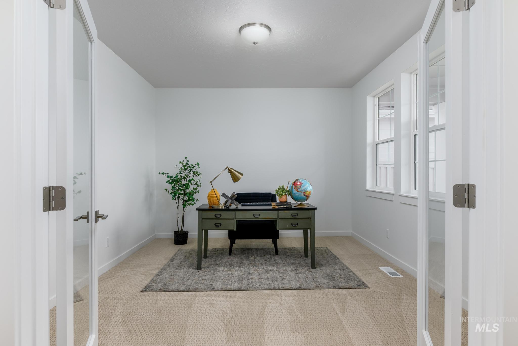 Office area with light carpet and french doors