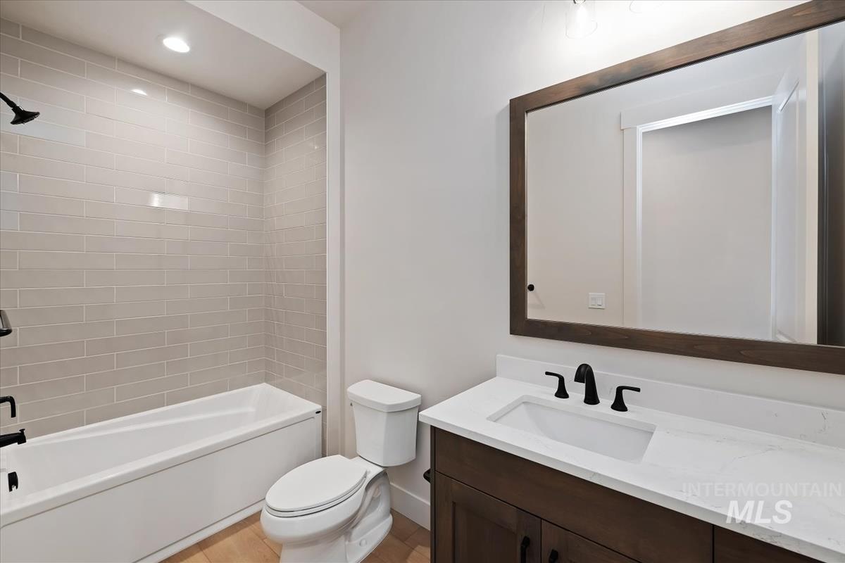 Full bathroom with vanity, tub / shower combination, and recessed lighting