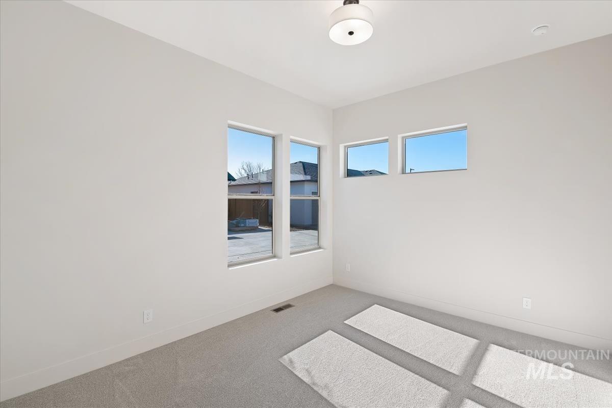 Empty room with carpet and healthy amount of natural light