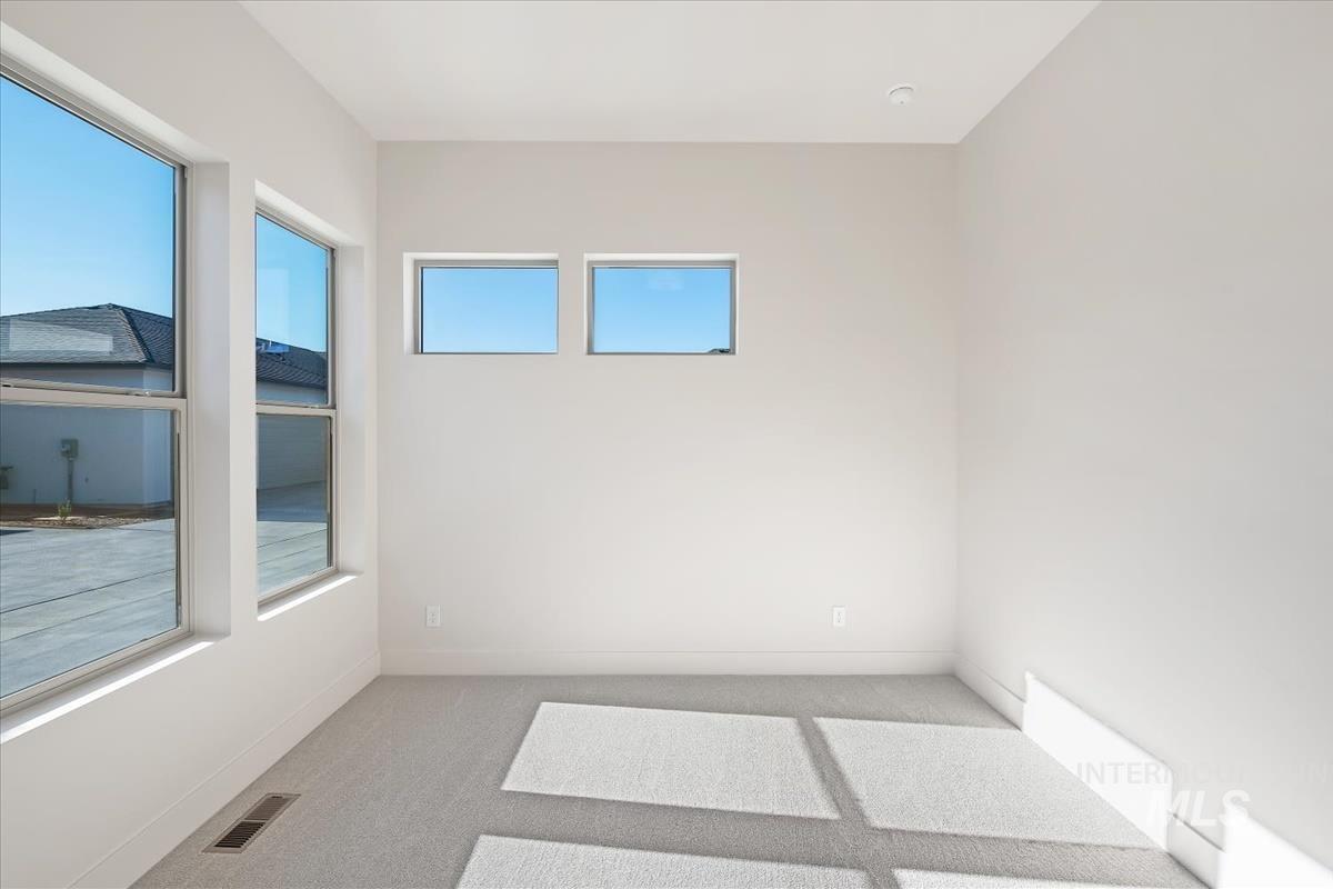 Unfurnished room with light carpet and baseboards