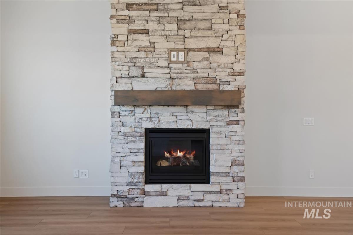 Detailed view of wood finished floors and a stone fireplace