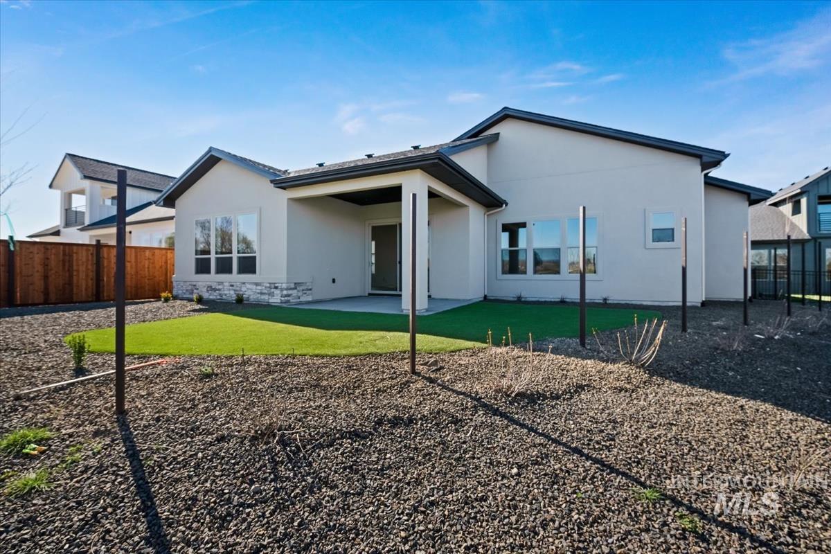 Rear view of property with a patio area, a fenced backyard, stucco siding, and stone siding