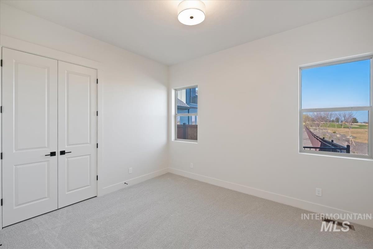 Unfurnished bedroom with light colored carpet and a closet