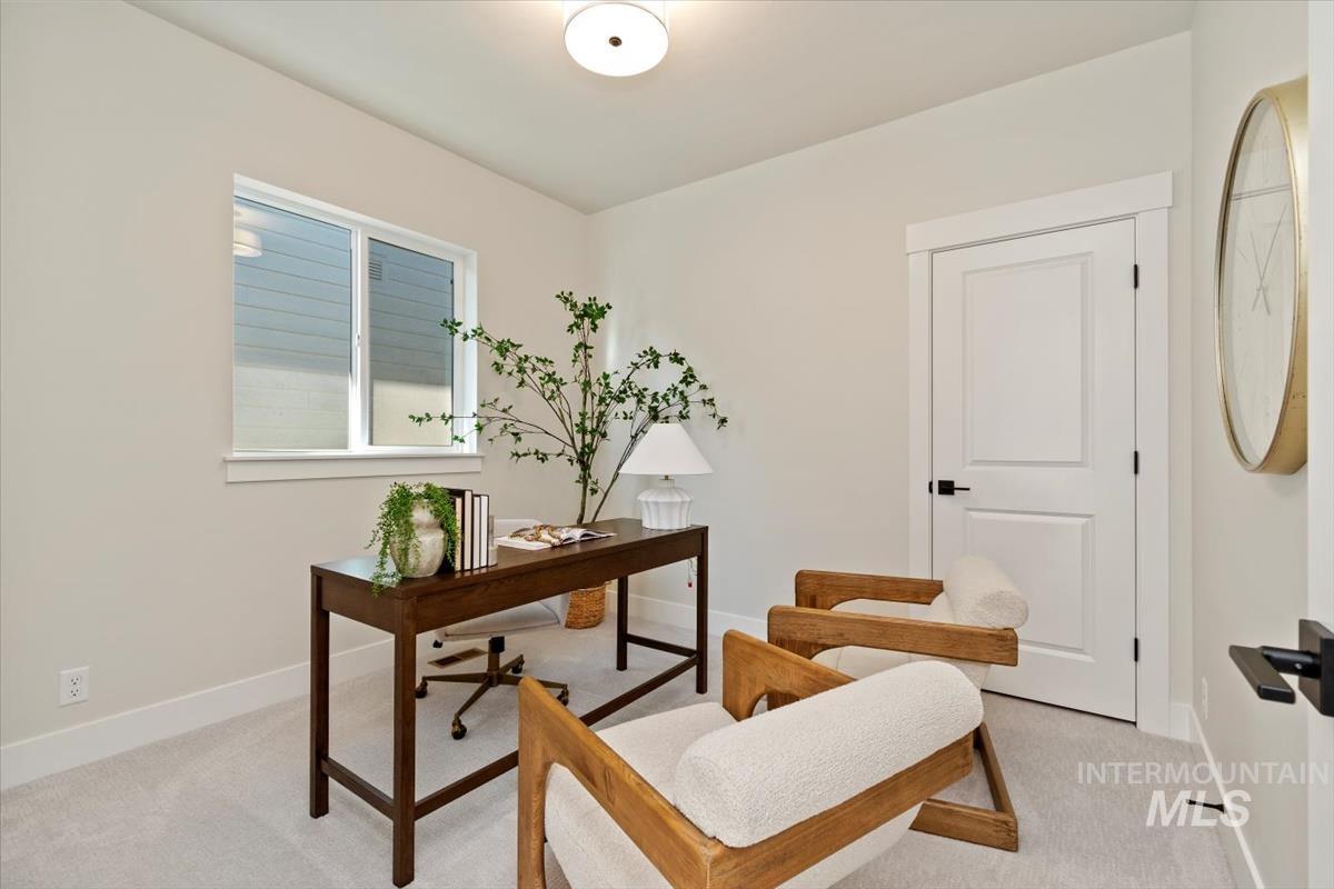 Home office with light carpet and baseboards