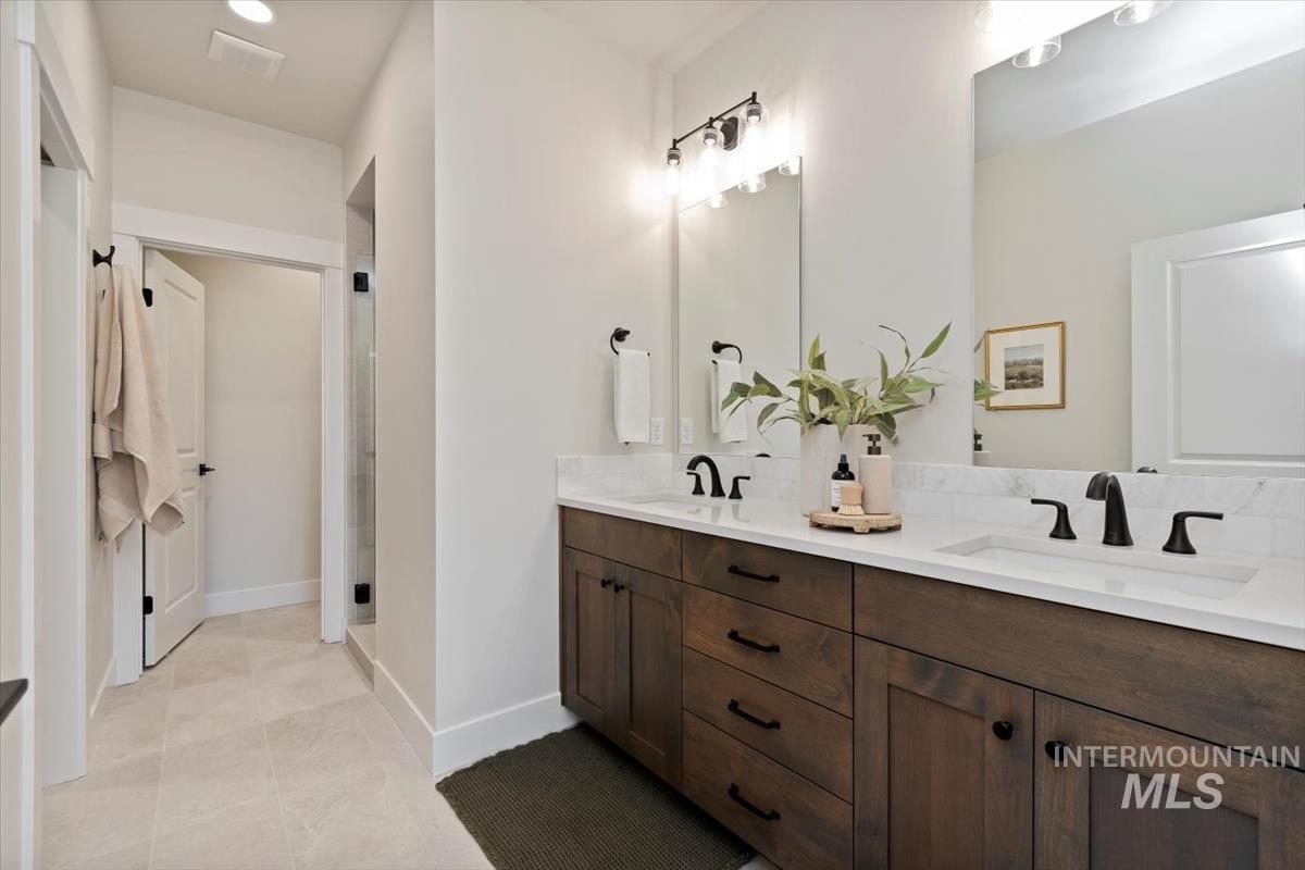 Bathroom featuring double vanity and a stall shower