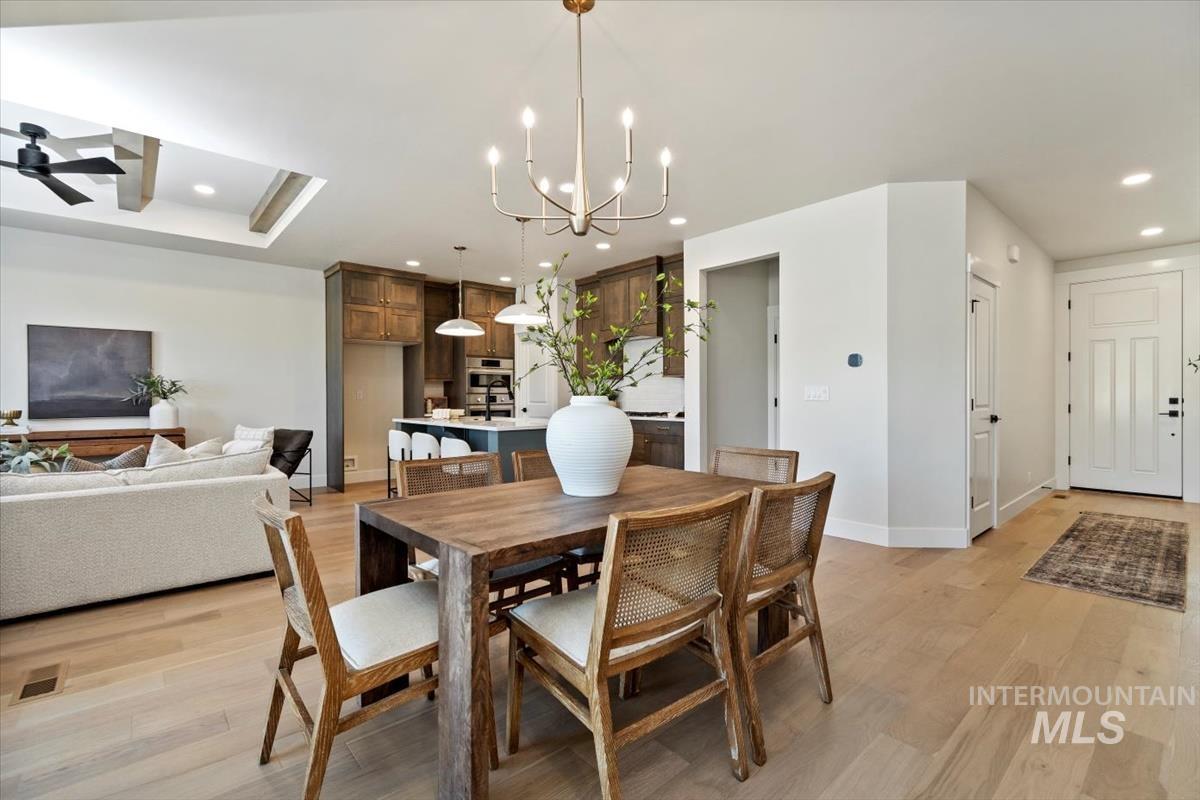 Dining area featuring recessed lighting, light wood-style flooring, ceiling fan, and a chandelier
