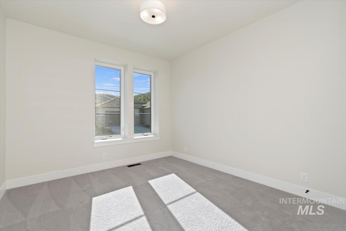Carpeted empty room with baseboards