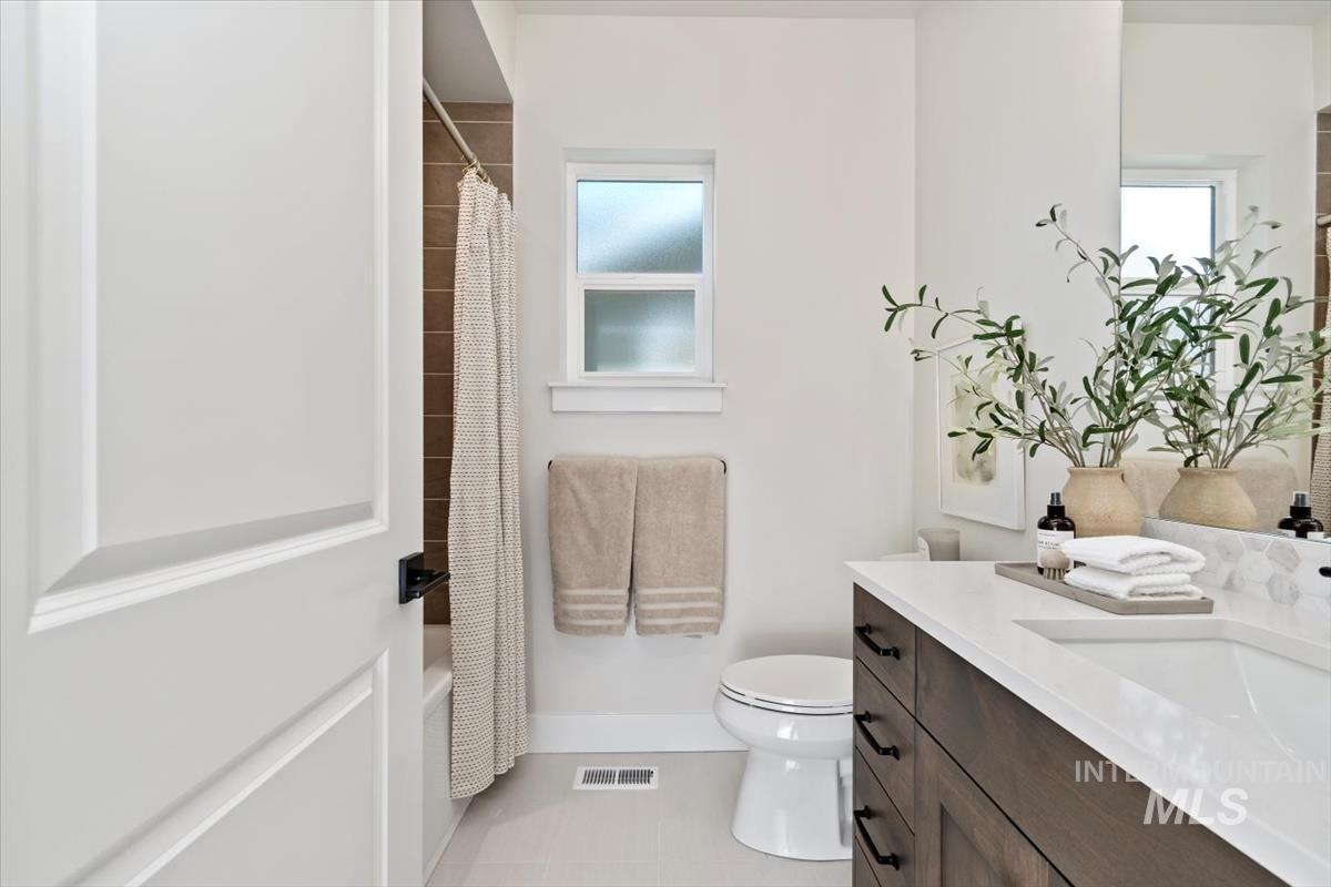 Full bath with vanity, tile patterned flooring, and shower / bathtub combination with curtain