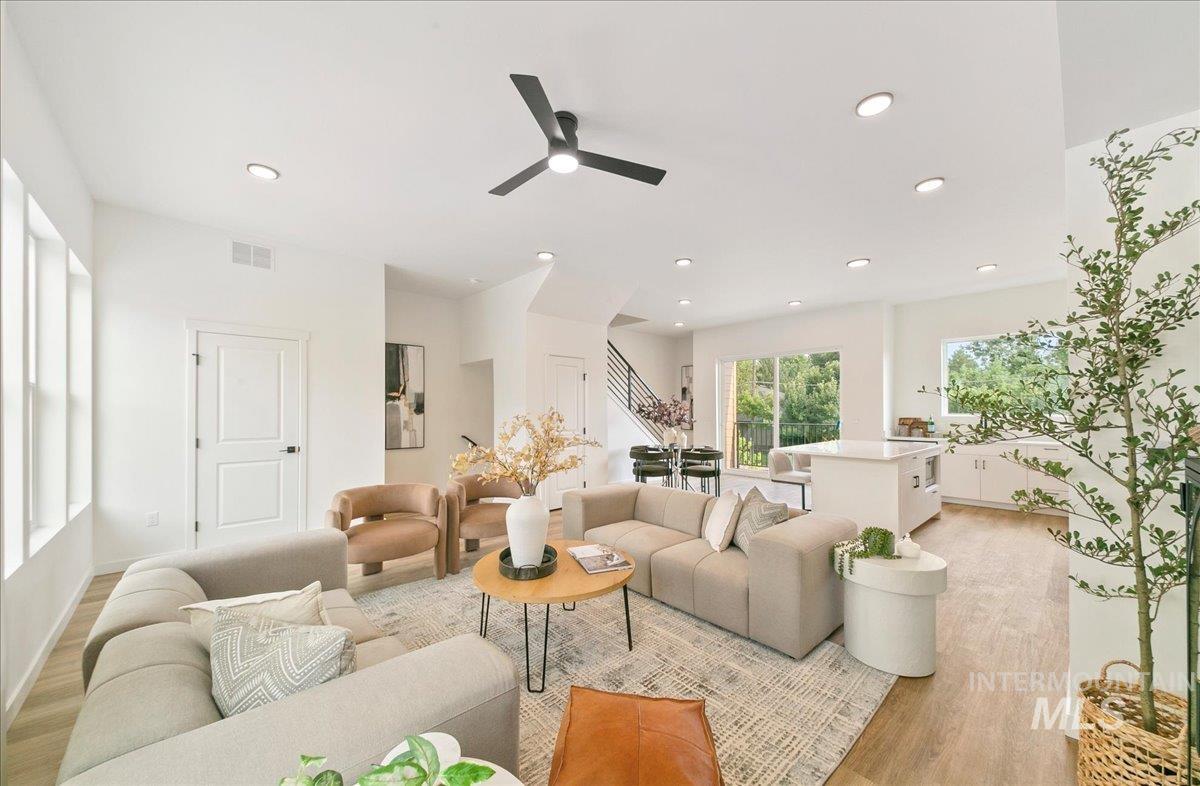 Living room with ceiling fan, light wood-type flooring, and recessed lighting