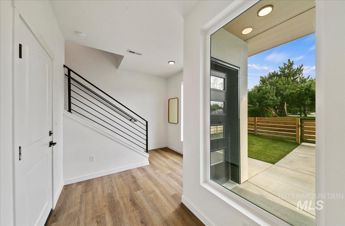 Entryway with wood finished floors, stairway, and recessed lighting